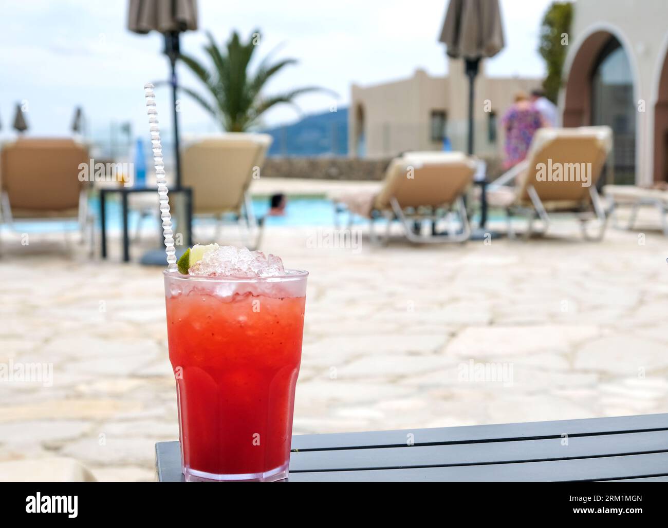 Verre d'un cocktail de fruits tropicaux au bord de la piscine Banque D'Images