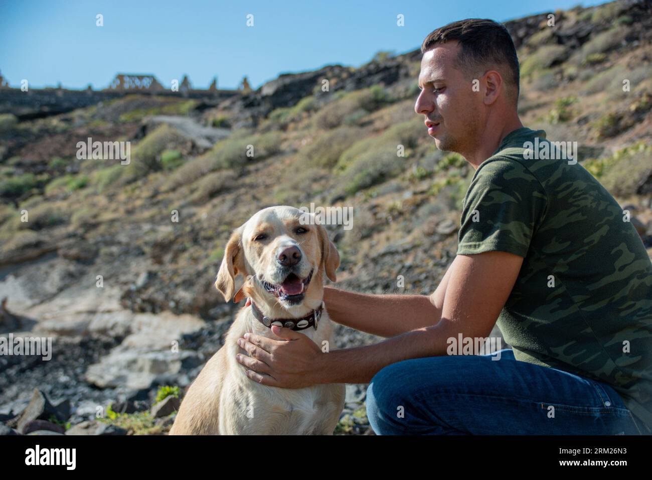 Le dresseur de chiens caucasiens câlins le chien labrador après une séance de travail réussie Banque D'Images