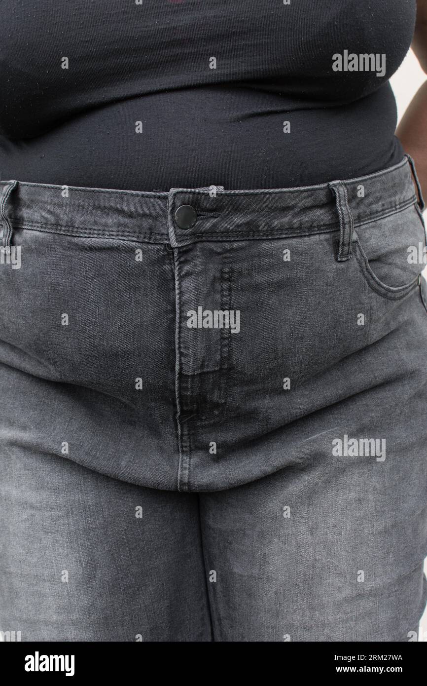 Femme en surpoids en jeans, femme avec une zone pubienne supérieure grasse en pantalon jean, Une fille de taille plus avec fupa en pantalon denim taille haute Banque D'Images