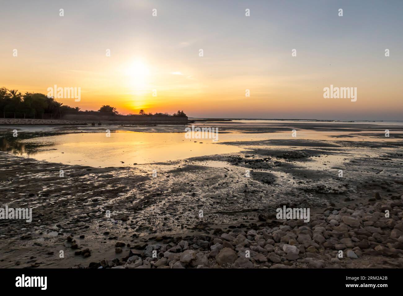 Coucher de soleil, Bahreïn Al-Seef, plage de Karbabad. Le pétrole déversé atteint la plage laissant des globs de pétrole Banque D'Images