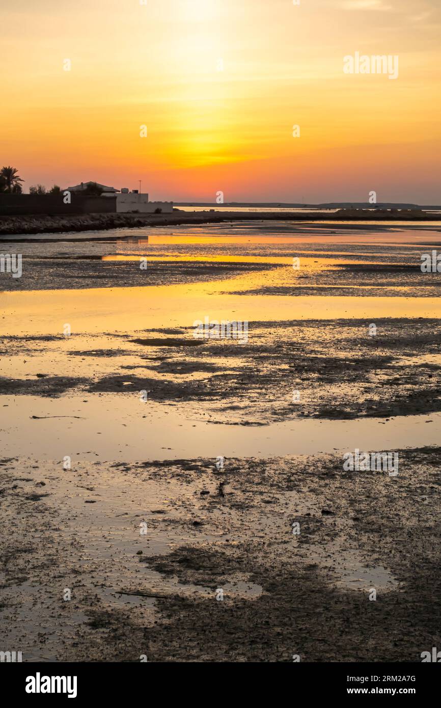 Coucher de soleil, Bahreïn Al-Seef, plage de Karbabad. Le pétrole déversé atteint la plage laissant des globs de pétrole Banque D'Images