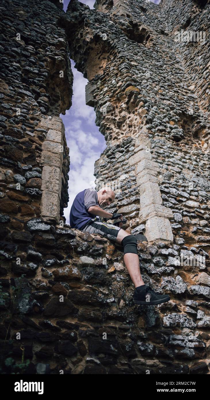 Un homme est assis sur la fenêtre de la ruine de l'église de St James près de Kings Lynn à Norfolk, Angleterre Royaume-Uni Banque D'Images