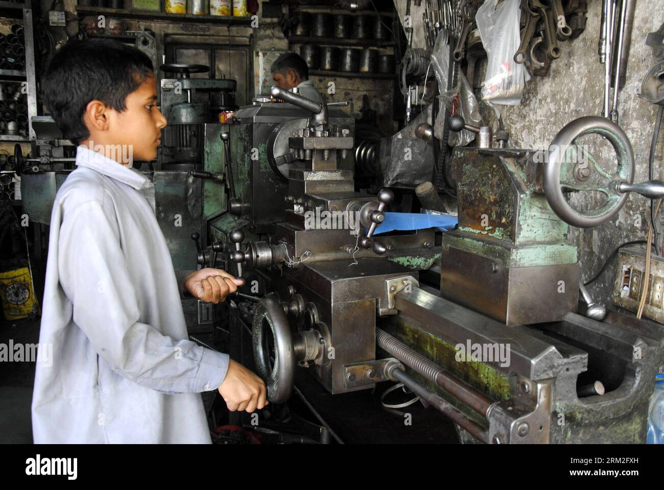 Un garçon pakistanais travaille dans un atelier de réparation à l'occasion de la Journée mondiale contre le travail des enfants à Lahore, dans l'est du Pakistan, le 12 juin 2013. L'Organisation internationale du travail a lancé la Journée mondiale contre le travail des enfants en 2002, qui tombe chaque 12 juin. Xinhua/Sajjad zw PAKISTAN-LAHORE-JOURNÉE MONDIALE CONTRE LE TRAVAIL DES ENFANTS PUBLICATIONxNOTxINxCHN Banque D'Images
