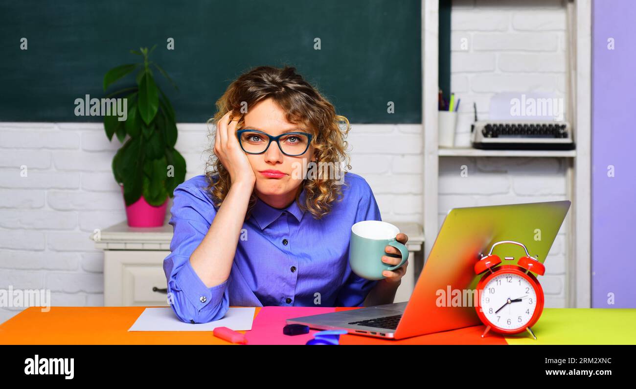 Retour à l'école. Enseignante fatiguée buvant du café en classe. Étudiant universitaire surchargé de travail se préparant à la session d'examen. Vacances scolaires Banque D'Images