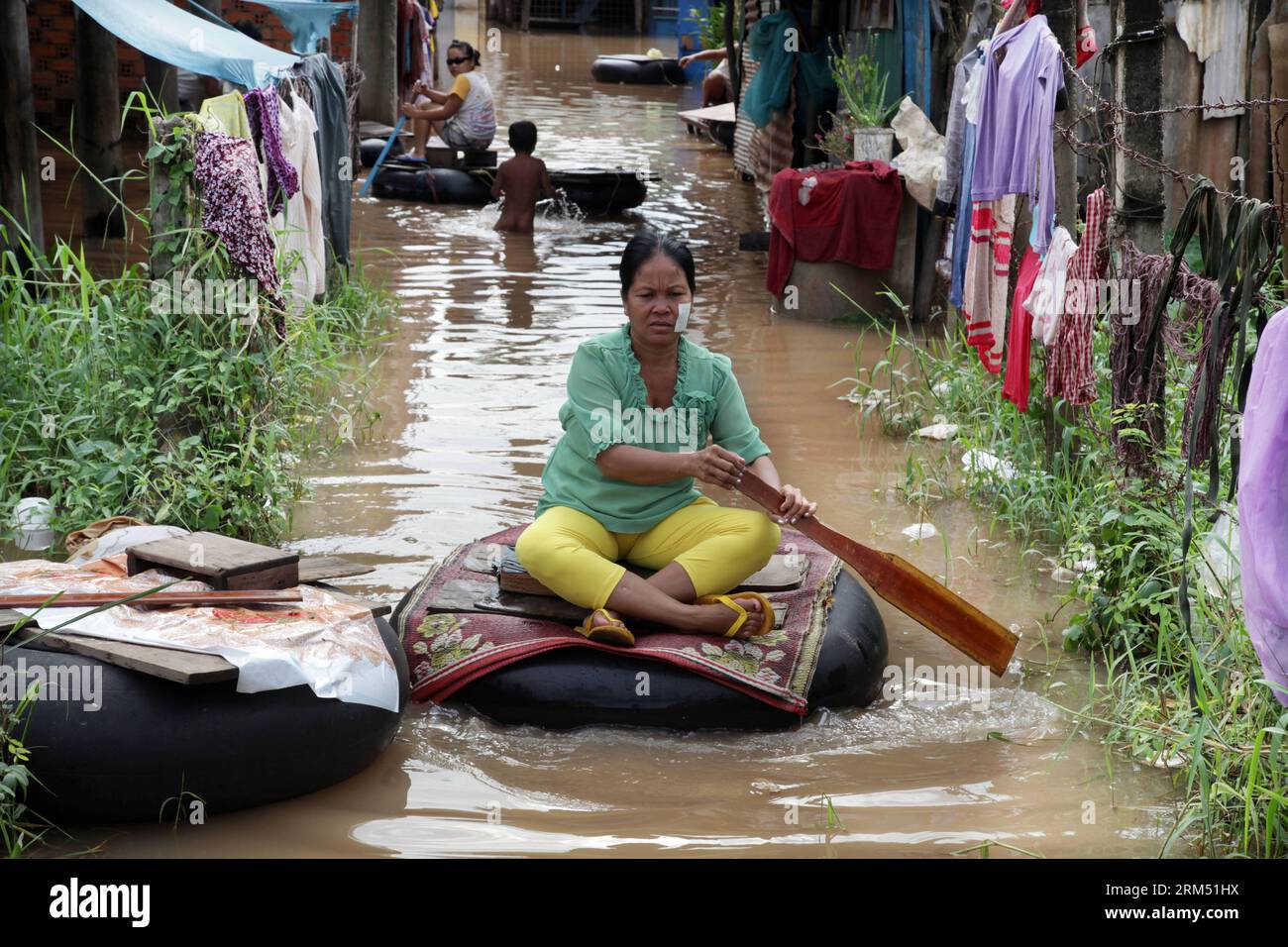 Bildnummer : 60549797 Datum : 01.10.2013 Copyright : imago/Xinhua (131001) -- PHNOM PENH, 1 octobre 2013 (Xinhua) -- Une femme est assise sur une voiture-tube flottante dans les eaux de crue à la périphérie de Phnom Penh, Cambodge, 1 octobre 2013. Au moins 30 au Cambodge sont morts de noyade en moins de trois semaines à cause du Mékong et des crues soudaines, a déclaré Keo Vy, chef de cabinet du Comité national pour la gestion des catastrophes. Les inondations ont forcé plus de 9 000 familles à fuir leurs maisons et inondé près de 100 000 hectares de rizières. (Xinhua/Phearum) CAMBODGE-KANDAL-INONDATION PUBLICATIONxNOTxINx Banque D'Images