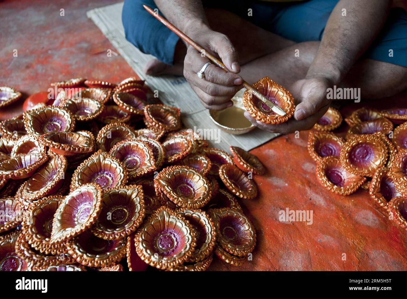 Bildnummer : 60660008 Datum : 31.10.2013 Copyright : imago/Xinhua (131031) -- CALCUTTA, 31 octobre 2013 (Xinhua) -- un potier indien colors diya (lampes en terre) en préparation de Diwali, la fête hindoue des lumières, à Calcutta, capitale de l'État indien oriental du Bengale occidental, le 31 octobre 2013. Les hindous du monde entier décorent leurs maisons avec des lampes en terre et des bougies allumées pour célébrer Diwali, selon la mythologie hindoue, le retour au pays du Seigneur Rama après avoir vaincu le roi Ravana, démon à dix têtes. (Xinhua/Tumpa Mondal)(lrz) INDIA-CALCUTTA-DIWALI PUBLICATIONxNOTxINxCHN xas x0x 2013 quer 60 Banque D'Images