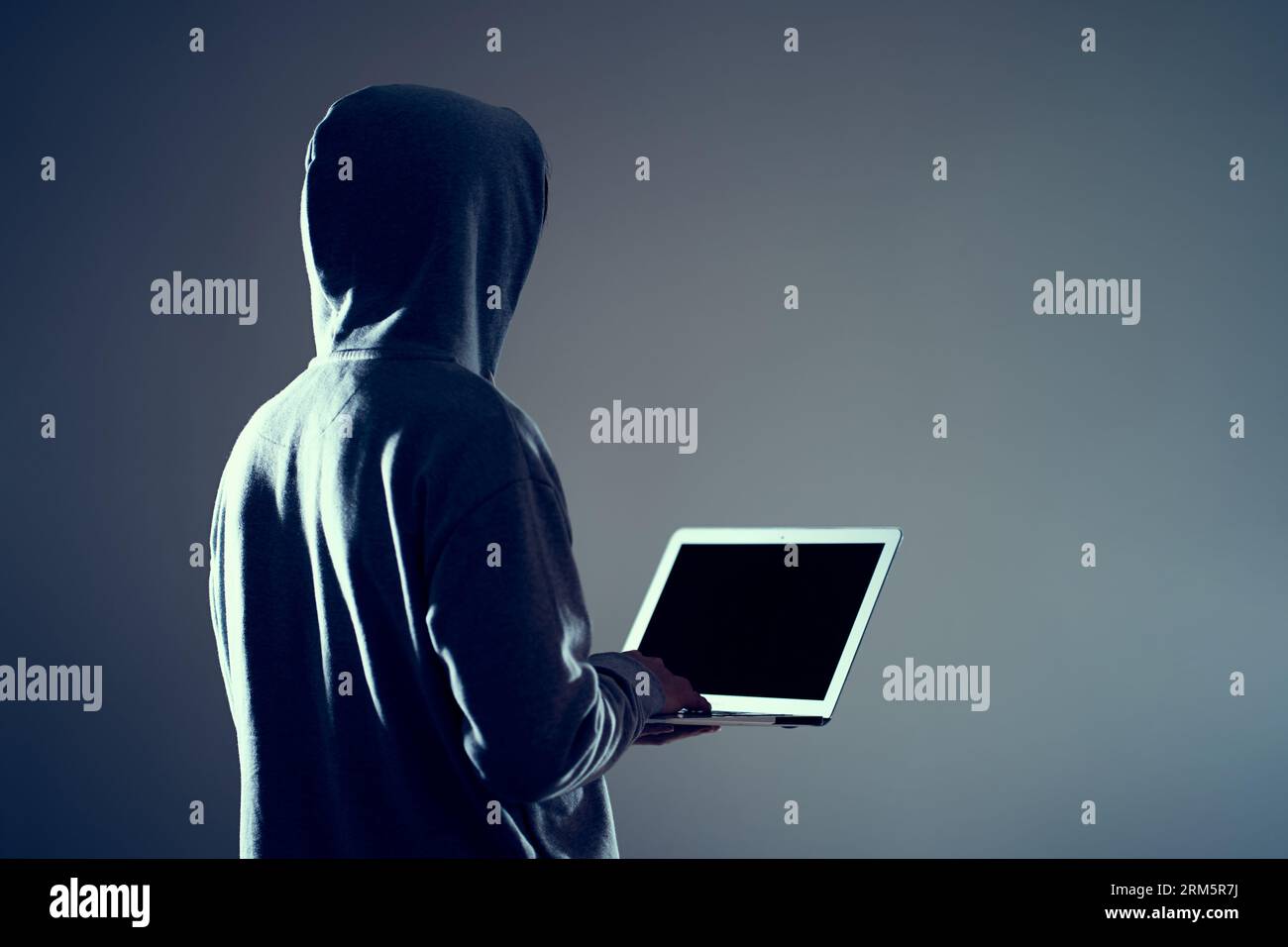 Pirate masculin écrivant du code sur un ordinateur portable Banque D'Images