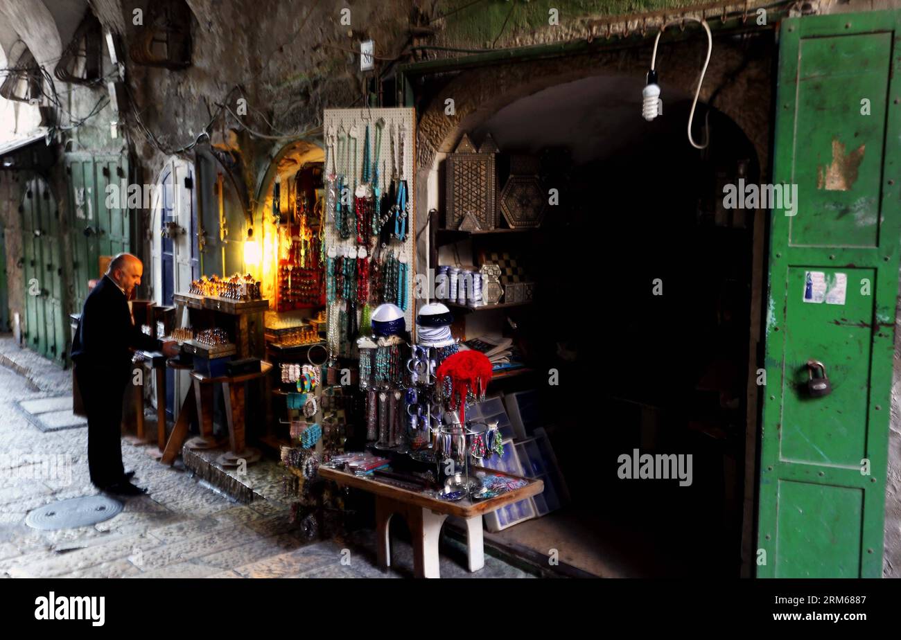 JÉRUSALEM, (Xinhua) -- Un propriétaire de magasin travaille dans la vieille ville de Jérusalem le 19 novembre 2013. Jérusalem, l'une des plus anciennes villes du monde, est sainte pour les trois grandes religions abrahamiques - le judaïsme, le christianisme et l'islam. Israéliens et Palestiniens revendiquent Jérusalem comme capitale, Israël y maintenant ses principales institutions gouvernementales. La vieille ville de Jérusalem a été traditionnellement divisée en quatre quartiers, à savoir les quartiers arménien, chrétien, juif et musulman. Il est devenu un site du patrimoine mondial en 1981, et est sur la liste du patrimoine mondial en péril. (Xinhua/Li Ying) JÉRUSALEM- Banque D'Images