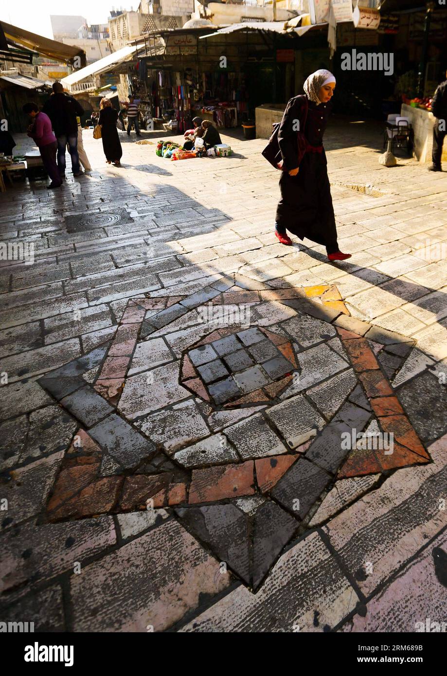 JÉRUSALEM, (Xinhua) -- Une femme marche dans la vieille ville de Jérusalem le 19 novembre 2013. Jérusalem, l'une des plus anciennes villes du monde, est sainte pour les trois grandes religions abrahamiques - le judaïsme, le christianisme et l'islam. Israéliens et Palestiniens revendiquent Jérusalem comme capitale, Israël y maintenant ses principales institutions gouvernementales. La vieille ville de Jérusalem a été traditionnellement divisée en quatre quartiers, à savoir les quartiers arménien, chrétien, juif et musulman. Il est devenu un site du patrimoine mondial en 1981, et est sur la liste du patrimoine mondial en péril. (Xinhua/Li Ying) JÉRUSALEM-MONDE Banque D'Images