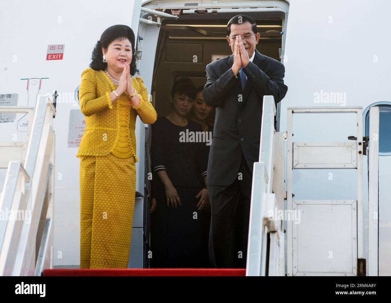 (131226) -- PHNOM PENH, 26 déc. 2013 (Xinhua) -- le Premier ministre cambodgien Hun Sen (à droite) et son épouse Bun Rany font un geste alors qu'ils partent pour une visite au Vietnam à Phnom Penh, Cambodge, le 26 décembre 2013. (Xinhua/Sovannara) CAMBODGE-PHNOM PENH-PM PUBLICATIONxNOTxINxCHN Banque D'Images