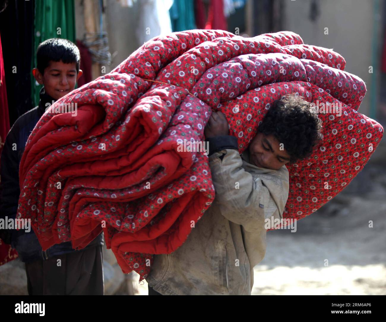 (131228) -- KABOUL, 28 déc. 2013 (Xinhua) -- un garçon afghan porte une couette offerte par le gouvernement allemand aux personnes déplacées à Kaboul, Afghanistan, 28 déc. 2013. (Xinhua/Ahmad Massoud) (djj) AFGHANISTAN-KABOUL-FOURNITURES DE SECOURS D'HIVER-DISTRIBUTION PUBLICATIONxNOTxINxCHN Kaboul DEC 28 2013 XINHUA à afghan Boy porte la patchwork don du gouvernement allemand pour les célébrités déplacées à Kaboul Afghanistan DEC 28 2013 XINHUA Ahmad Massoud Afghanistan Kaboul FOURNITURES DE secours d'hiver distribution PUBLICATIONxNOTxINxCHN Banque D'Images