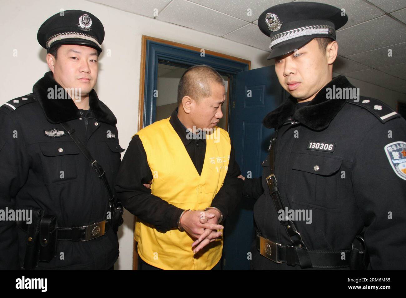 (140120) -- SHIJIAZHUANG, 20 janvier 2014 (Xinhua) -- Lyu Yueting (C) est escorté à son procès devant le tribunal populaire intermédiaire municipal de Shijiazhuang à Shijiazhuang, capitale de la province du Hebei du nord de la Chine, le 20 janvier 2014. LYU a été condamné à la prison à vie pour avoir ajouté du poison à des boulettes congelées qui ont laissé malades quatre Chinois et neuf Japonais. Le tribunal populaire intermédiaire municipal de Shijiazhuang a rendu le verdict lundi lors d'une audience publique en présence de journalistes et de fonctionnaires de l'ambassade du Japon en Chine. (Xinhua/Ding Lixin) (lmm) CHINA-SHIJIAZHUANG-DUMPLING Banque D'Images