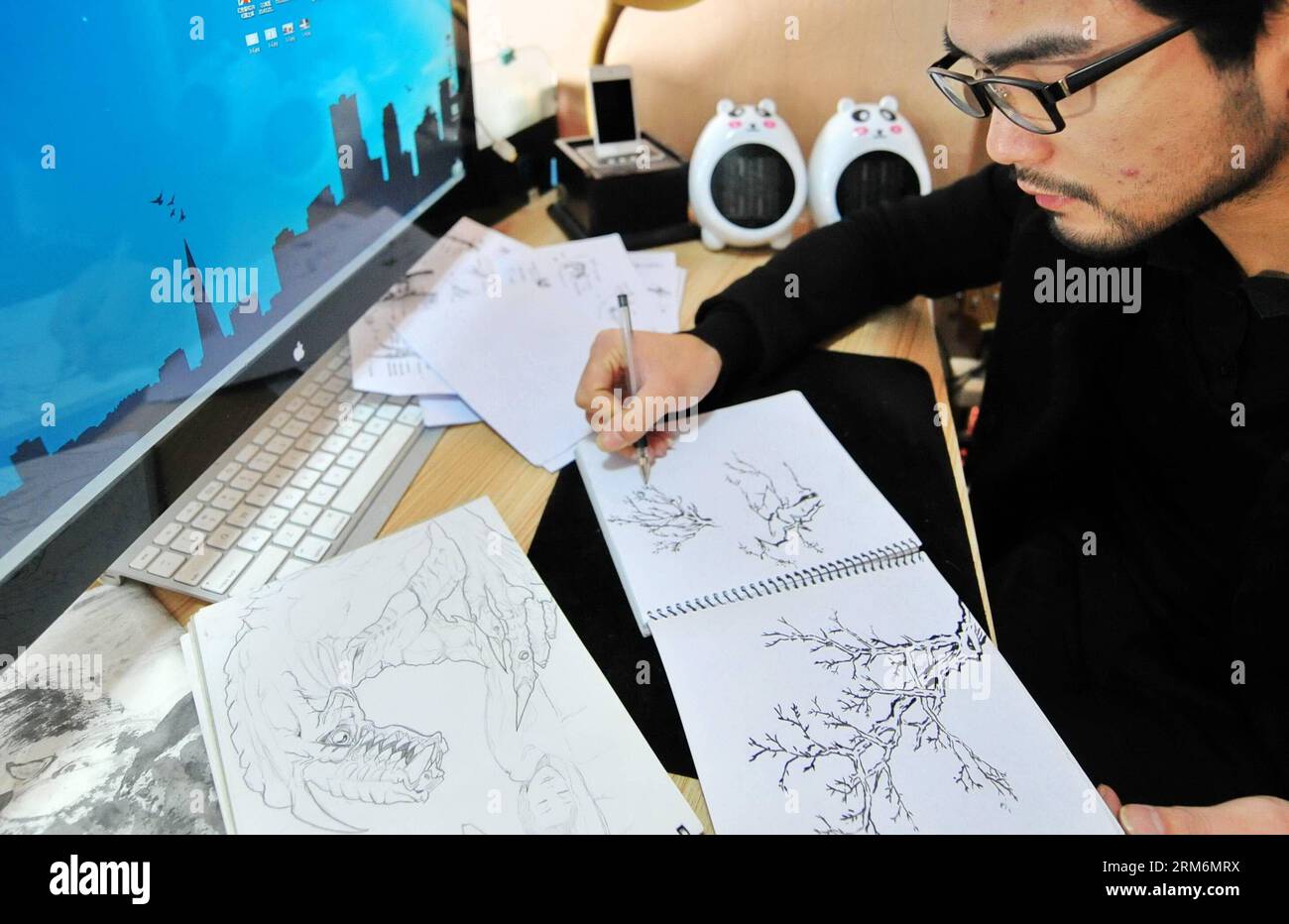 (140121) -- FUZHOU, 21 janvier 2014 (Xinhua) -- Liu Hongxin dessine des croquis pour la peinture lumineuse dans son atelier de Fuzhou, capitale de la province du Fujian du sud-est de la Chine, le 21 janvier 2014. Major en génie électrique, Liu Hongxin est tombé amoureux de l'art de la peinture légère à l'été 2010. Liu était encore étudiant à l'université à l'époque et, avec ses propres efforts, a appris la peinture lumineuse à partir de clips vidéo mettant en scène des artistes étrangers. Après plus d un an de pratique, le peintre lumière autodidacte a fait ses débuts en octobre 2011, et a tenu près de 100 représentations eversince. En décembre 2013, Lin Banque D'Images