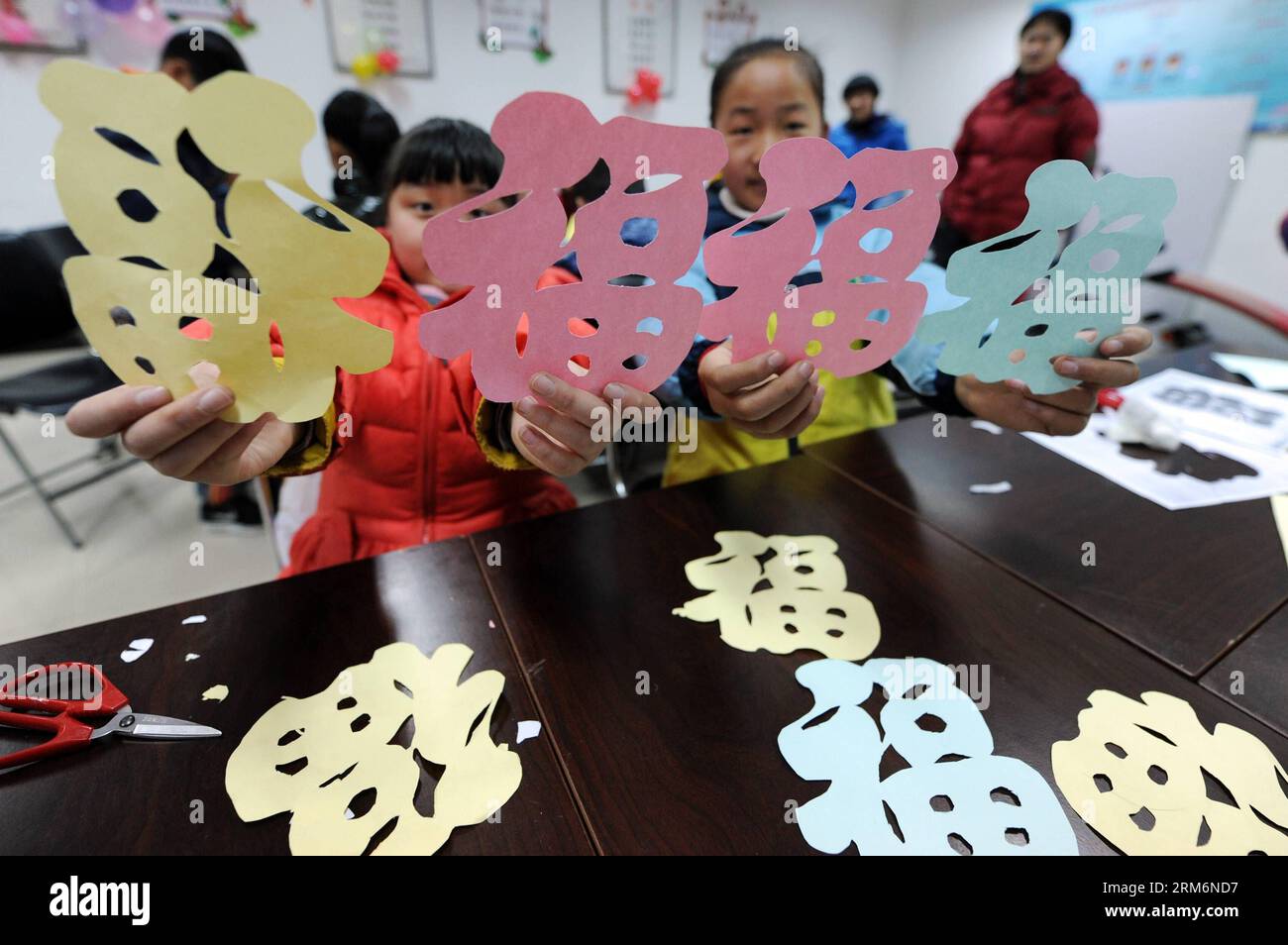 (140122) -- HANGZHOU, 22 janvier 2014 (Xinhua) -- Pang Yanan (L), une fillette de 11 ans, montre ses œuvres de découpe de papier avec des caractères chinois lisant Fu , ce qui signifie bonheur, pour saluer le prochain Festival du printemps dans la ville de Hangzhou, capitale de la province du Zhejiang de l'est de la Chine, le 22 janvier 2014. La fête du printemps tombe le 31 janvier cette année. (Xinhua/Ju Huanzong) (ry) CHINA-HANGZHOU-SPRING FESTIVAL-CUSTOM (CN) PUBLICATIONxNOTxINxCHN Hangzhou Jan 22 2014 XINHUA Pang Yanan l à 11 ans fille montre ses œuvres de découpe de papier de caractères chinois lecture Fu qui signifie BONHEUR de saluer le prochain Sprin Banque D'Images