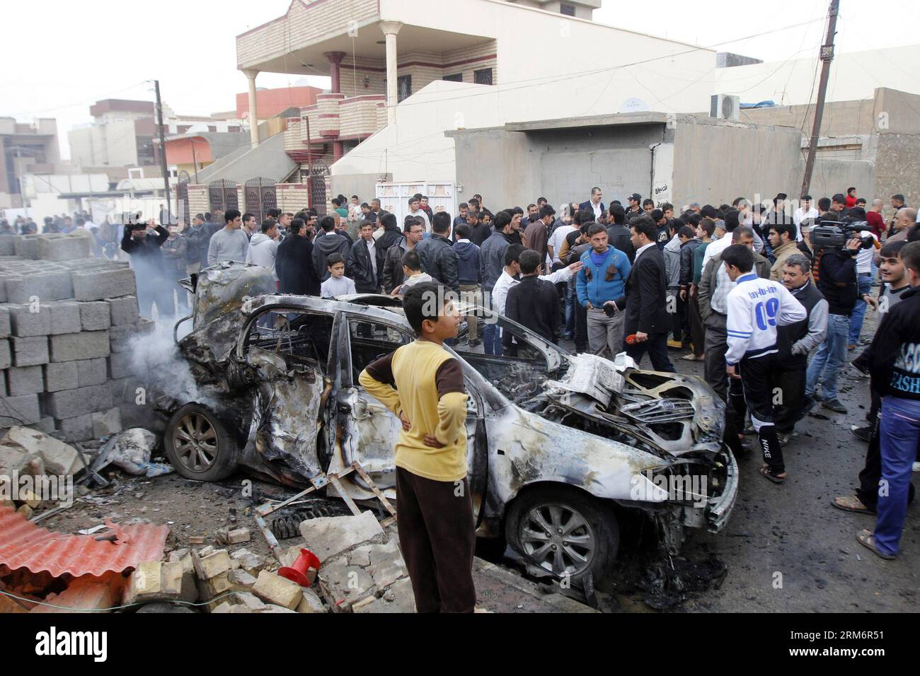 (140126) -- KIRKOUK, 26 janv. 2014 (Xinhua) -- des gens se rassemblent autour d'un véhicule endommagé sur le site de l'explosion à Kirkouk, Irak, le 26 janvier 2014. Au moins quatre personnes ont été tuées et 14 blessées dans l'après-midi lorsque trois voitures piégées ont explosé presque simultanément dans des quartiers distincts de la ville de Kirkouk, à environ 250 km au nord de Bagdad, la capitale irakienne, a déclaré à Xinhua une source policière locale sous couvert d'anonymat. (Xinhua/Dena Assad) (zjl) IRAK-KIRKOUK-BLAST PUBLICATIONxNOTxINxCHN Kirkouk Jan 26 2014 des célébrités XINHUA se rassemblent autour d'un véhicule endommagé SUR le site de Blast à Kirkouk Irak LE 26 2 janvier Banque D'Images