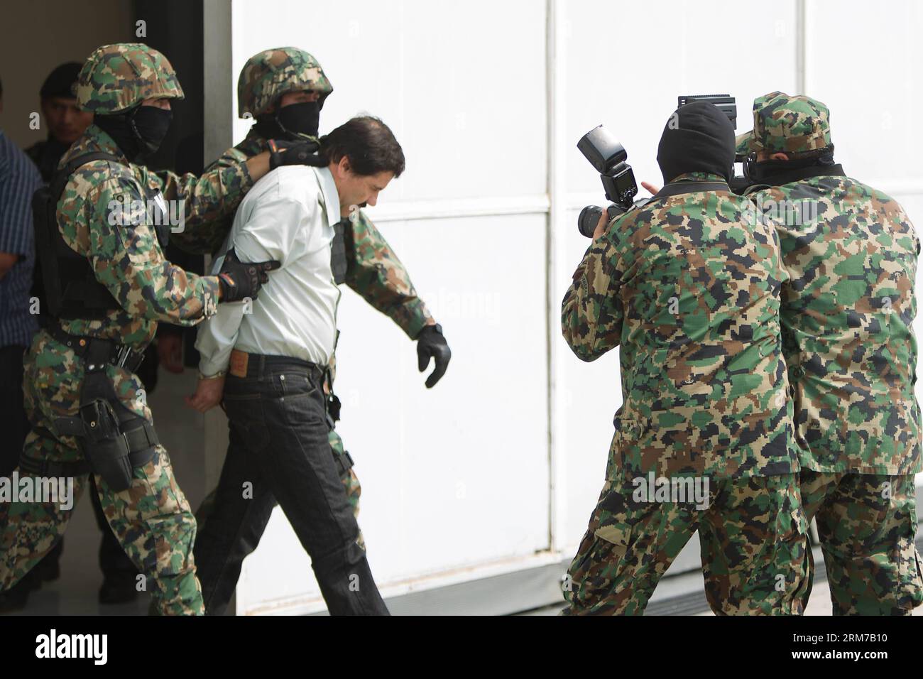 (140222) -- MEXICO, 22 février 2014 (Xinhua) -- des soldats de la Marine mexicaine escortent Joaquin Guzman Loera (C), alias El Chapo Guzman , chef du cartel Sinaloa, lors de sa présentation devant la presse, au hangar de la Marine mexicaine à Mexico, capitale du Mexique, le 22 février 2014. Le président mexicain Enrique Pena Nieto a confirmé samedi la capture du seigneur de la drogue le plus recherché au monde, Joaquin Guzman Loera, connu sous le nom d'El Chapo, dans la station balnéaire pacifique de Mazatlan. (Xinhua/Zhang Jiayang) (ce) (ah) MEXICO-SINALOA-DRUG Lord-CAPTUERE PUBLICATIONxNOTxINxCHN Mexico 22 2014 février XINHUA MEXICAN Na Banque D'Images