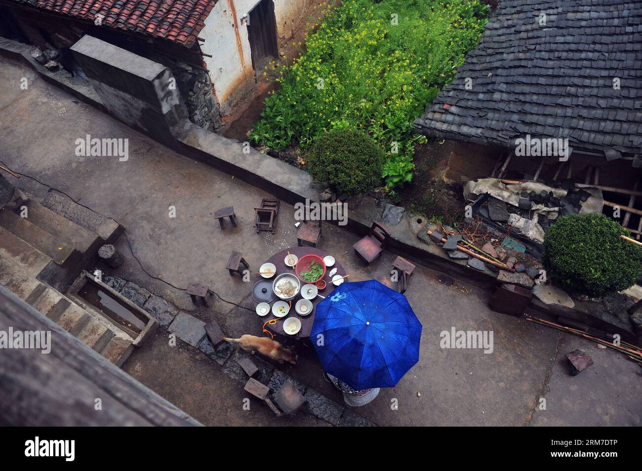 Les touristes déjeunent sous la pluie dans une maison de villageois dans le village de Tongban, comté de Rong an, région autonome de Guangxi Zhuang, sud de la Chine, le 22 février 2014. Le village de Tongban, situé dans les zones montagneuses du comté de Rong an dans la région autonome de Guangxi Zhuang, était autrefois un petit village de plus de 100 habitants qui gagnaient leur vie en plantant des pruniers. Depuis les années 1990, la jeune génération de Tongban a abandonné la vie là-bas et commencé à travailler dans les villes. Alors que de plus en plus de jeunes quittaient la ville natale, le village autrefois animé était sur le déclin avec seulement quelques villageois âgés demeurant Banque D'Images