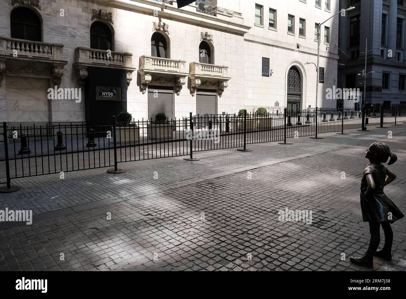 Vue de The Fearless Girl, une sculpture en bronze sur Broad Street en face du New York stock Exchange Building à Manhattan, New York. Banque D'Images