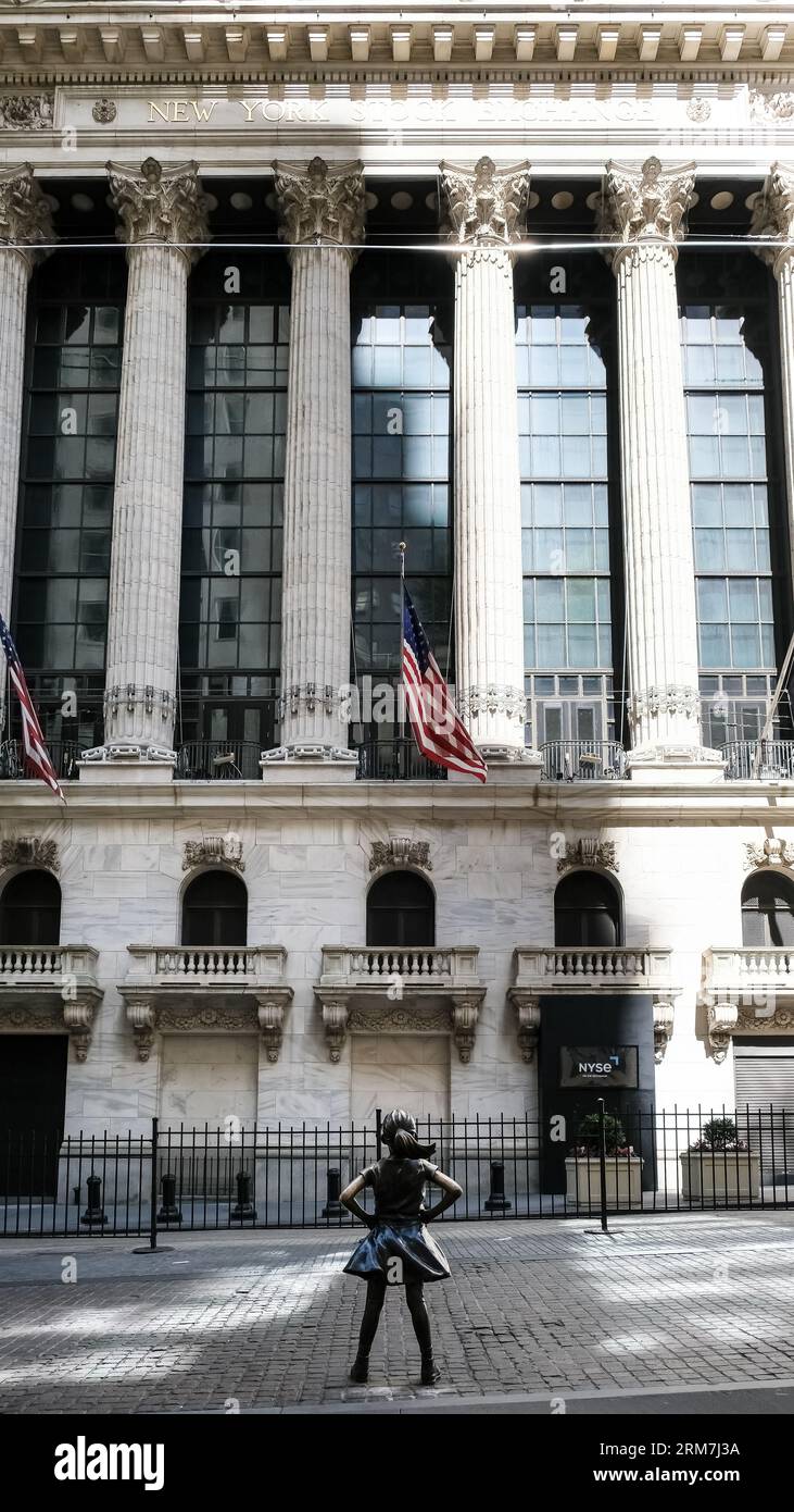 Vue de The Fearless Girl, une sculpture en bronze sur Broad Street en face du New York stock Exchange Building à Manhattan, New York. Banque D'Images