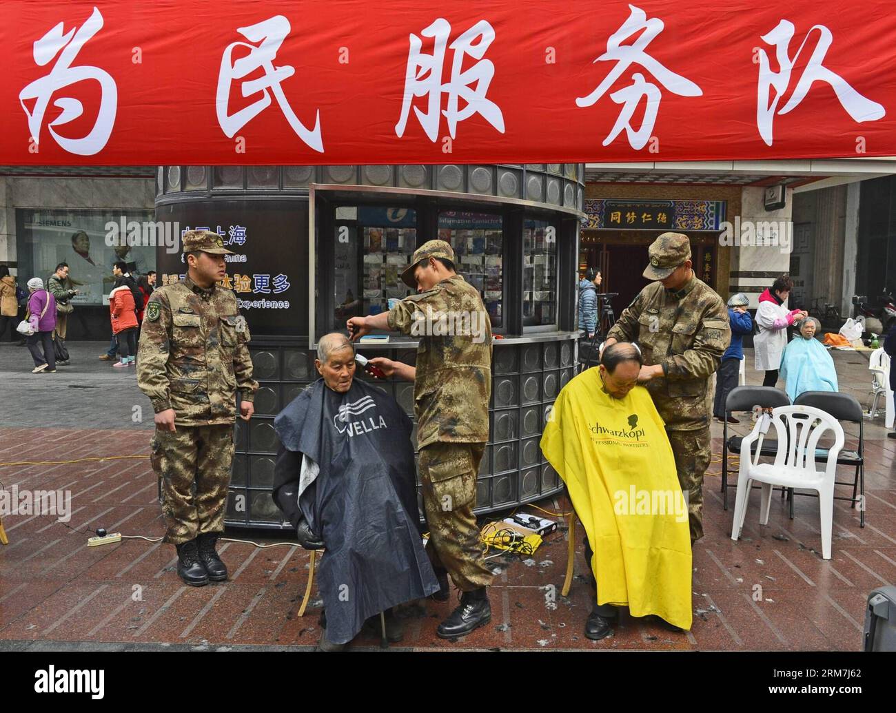 (140305) -- SHANGHAI, 5 mars 2014 (Xinhua) -- des soldats offrent un service gratuit de coupe de cheveux aux citoyens de Shanghai, dans l'est de la Chine, le 5 mars 2014, à l'occasion de la Journée du Lei Feng, qui tombe le 5 mars de chaque année. Lei, un jeune soldat chinois dans les années 1960, est connu pour consacrer presque tout son temps libre et son argent à aider de manière désintéressée les nécessiteux. Il est mort après avoir été frappé par un poteau tombant alors qu’il aidait un collègue soldat à diriger un camion le 15 août 1962. (Xinhua/Guo Changyao) (ry) CHINA-LEI FENG SPIRIT-ACTIVITIES (CN) PUBLICATIONxNOTxINxCHN Shanghai Mars 5 2014 les soldats de XINHUA OFFRENT une coupe de cheveux gratuite Banque D'Images