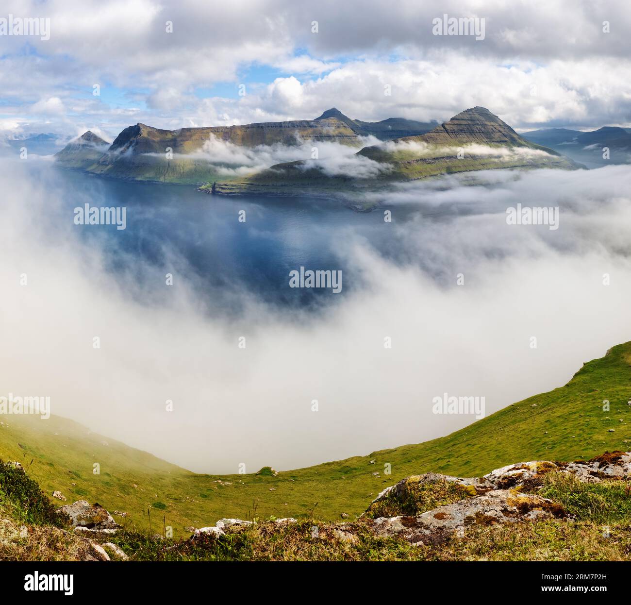 Panorama de paysage de montagne avec océan. Brouillard au-dessus du fjord Funningur sur l'île d'Eysturoy, îles Féroé. Banque D'Images
