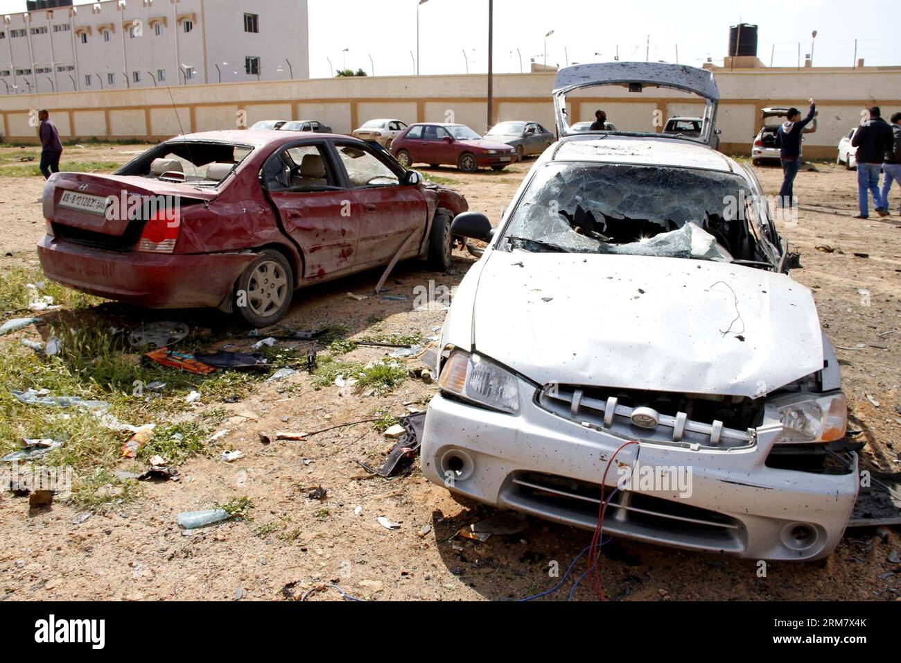 (140317) -- BENGHAZI, 17 mars 2014 (Xinhua) -- des gens vérifient les voitures endommagées à Benghazi, Libye, 17 mars 2014. Une voiture piégée ciblant un camp militaire libyen à Benghazi a tué au moins cinq soldats et blessé dix autres lundi, ont déclaré des sources militaires et médicales à Xinhua. (Xinhua/Mohammed Elshaiky) LIBYA-BENGHAZI-MILITARY-CAMP-BOMB-ATTACK PUBLICATIONxNOTxINxCHN Benghazi Mars 17 2014 célébrités XINHUA vérifier les voitures endommagées à Benghazi Libye Mars 17 2014 une voiture piégée visant un camp militaire libyen à Benghazi A TUÉ au moins cinq soldats et blessé dix autres lundi militaire et médical S. Banque D'Images