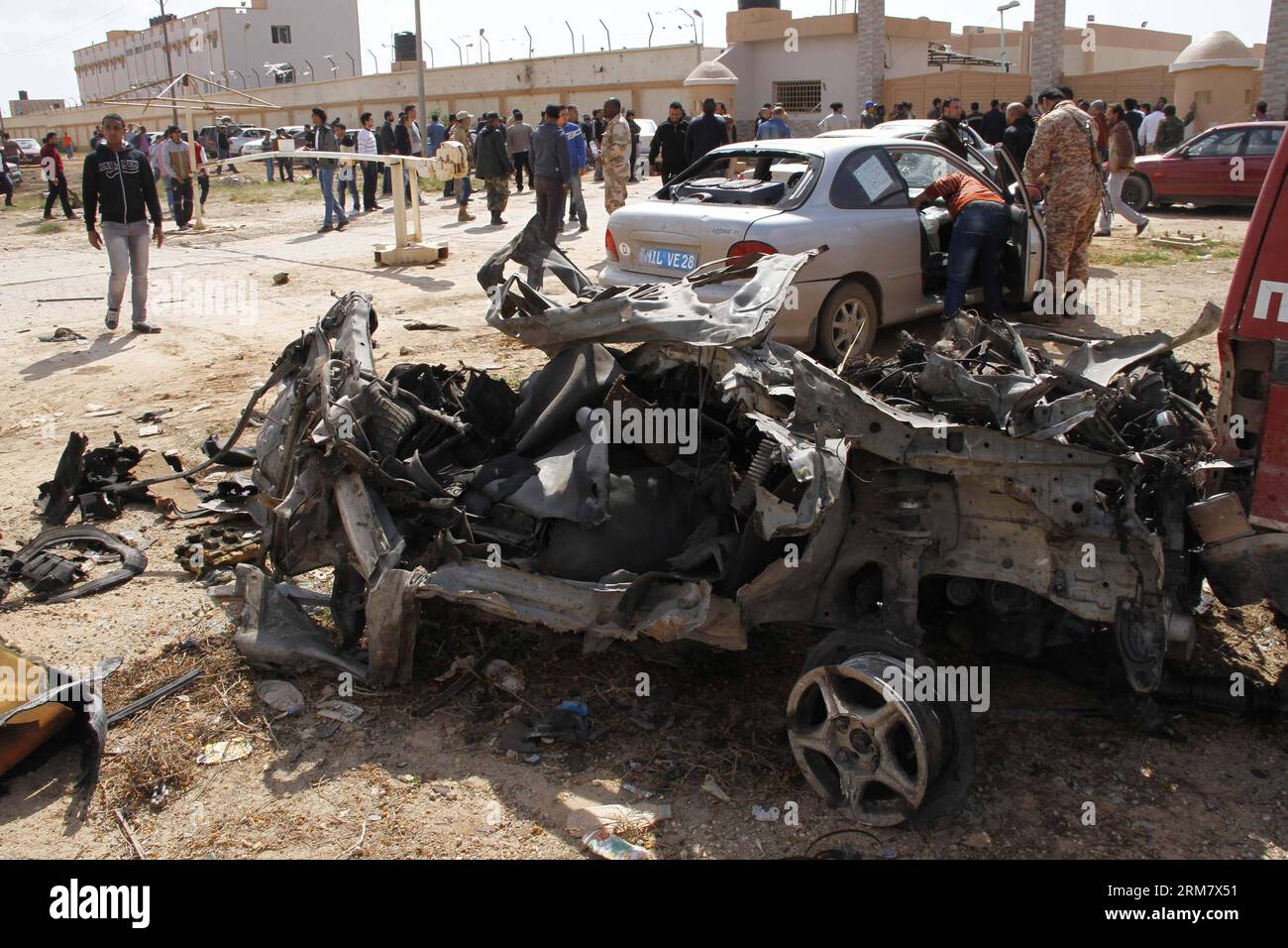 (140317) -- BENGHAZI, 17 mars 2014 (Xinhua) -- des gens vérifient les voitures endommagées à Benghazi, Libye, 17 mars 2014. Une voiture piégée ciblant un camp militaire libyen à Benghazi a tué au moins cinq soldats et blessé dix autres lundi, ont déclaré des sources militaires et médicales à Xinhua. (Xinhua/Mohammed Elshaiky) LIBYA-BENGHAZI-MILITARY-CAMP-BOMB-ATTACK PUBLICATIONxNOTxINxCHN Benghazi Mars 17 2014 célébrités XINHUA vérifier les voitures endommagées à Benghazi Libye Mars 17 2014 une voiture piégée visant un camp militaire libyen à Benghazi A TUÉ au moins cinq soldats et blessé dix autres lundi militaire et médical S. Banque D'Images