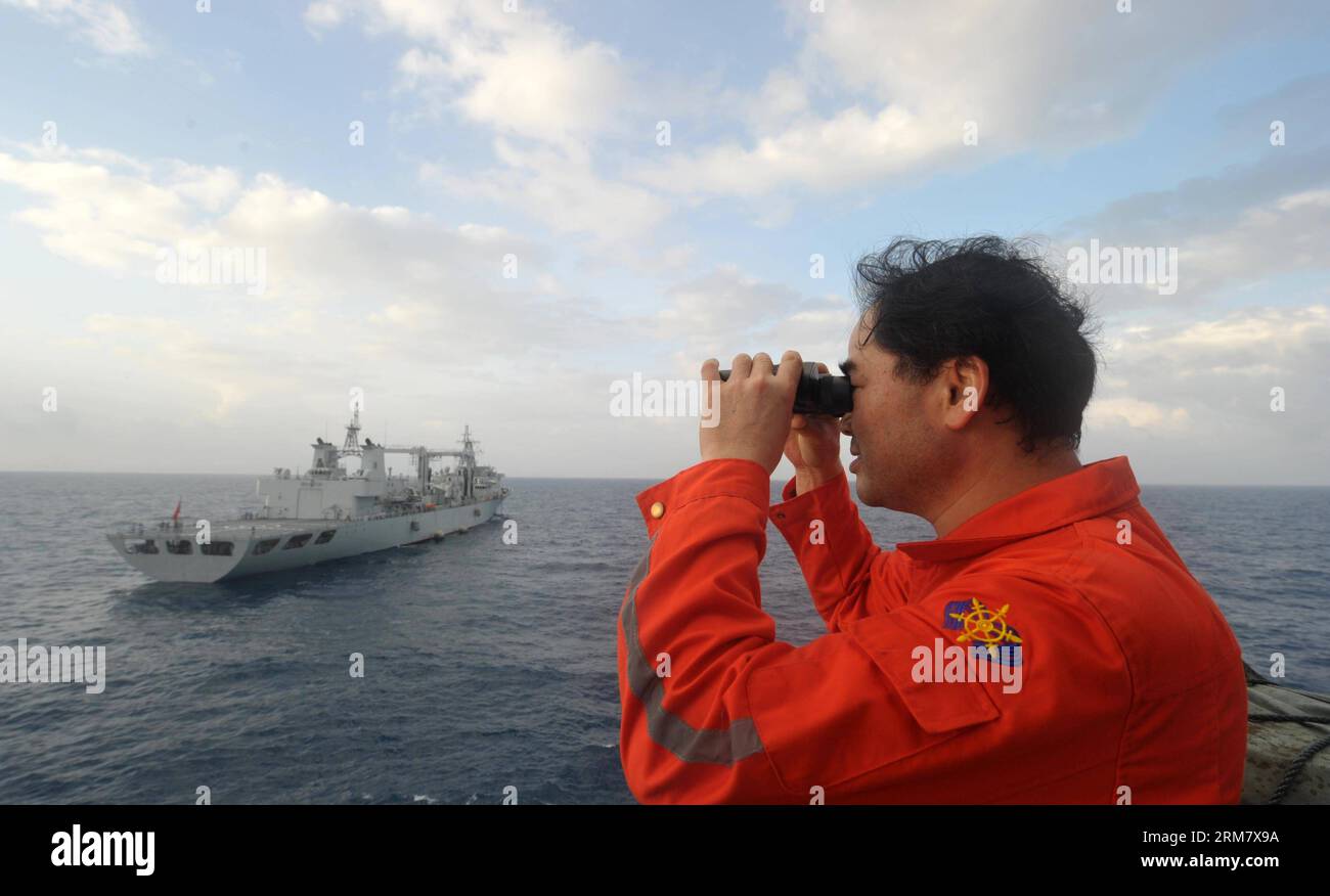 (140318) -- À BORD DE NANHAIJIU 101, 18 mars 2014 (Xinhua) -- vice-commandant du navire de sauvetage chinois Nanhaijiu 101 Zhang Jianxin regarde le navire approcher le navire de ravitaillement complet Qiandaohu, alors que les deux se dirigent vers Singapour pour se joindre à la recherche du vol MH370 disparu de Malaysia Airlines, le 18 mars 2014. Mardi à 8:00 heures du matin, le ministère chinois des Transports a ordonné à tous les navires chinois dans le golfe de Thaïlande de partir pour des recherches dans les eaux au sud-est de la baie du Bengale et près du détroit de la sonde. (Xinhua/Zhao Yingquan) NANHAIJIU 101-CHINA-RESCUE SHIPS PUBLICATIONxNOTx Banque D'Images
