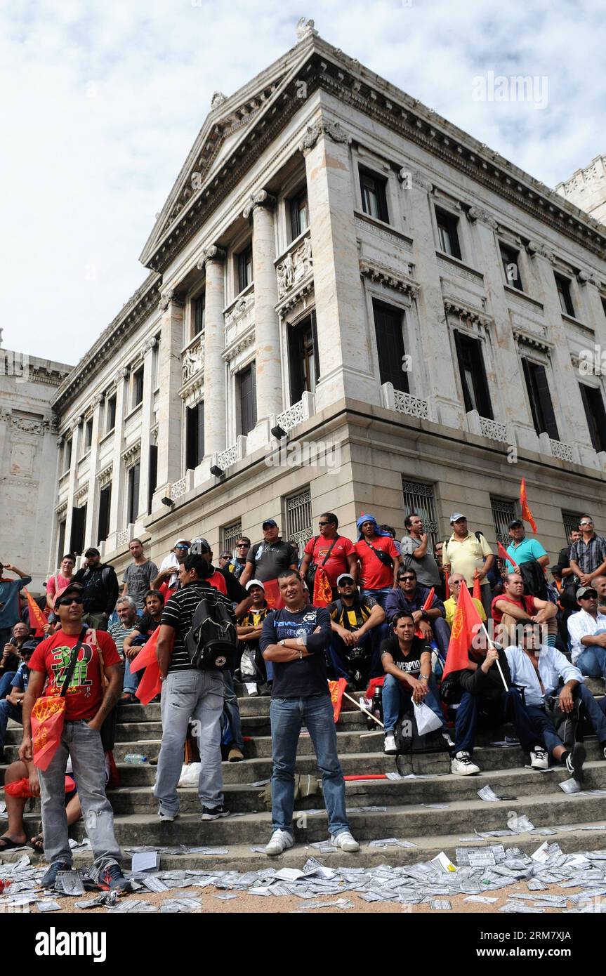 (140319) - MONTEVIDEO, (Xinhua) -- les travailleurs de la seule Union nationale de la construction et des annexes (SUNCA, pour son acronyme en espagnol), participent à une manifestation pour exiger le vote du projet de loi sur la responsabilité pénale des entreprises, devant le Parlement lors d’une session au Sénat, à Montevideo, capitale de l’Uruguay, le 18 mars 2014. La loi sur la responsabilité pénale des entreprises pourrait punir de 3 à 24 mois de prison les employés qui n'adoptent pas de mesures de sécurité. (Xinhua/Nicolas Celaya) (jg) (sp) URUGUAY-MONTEVIDEO-SOCIETY-DEMONSTRATION PUBLICATIONxNOTxINxCHN Montevideo XINHUA travailleurs de Banque D'Images