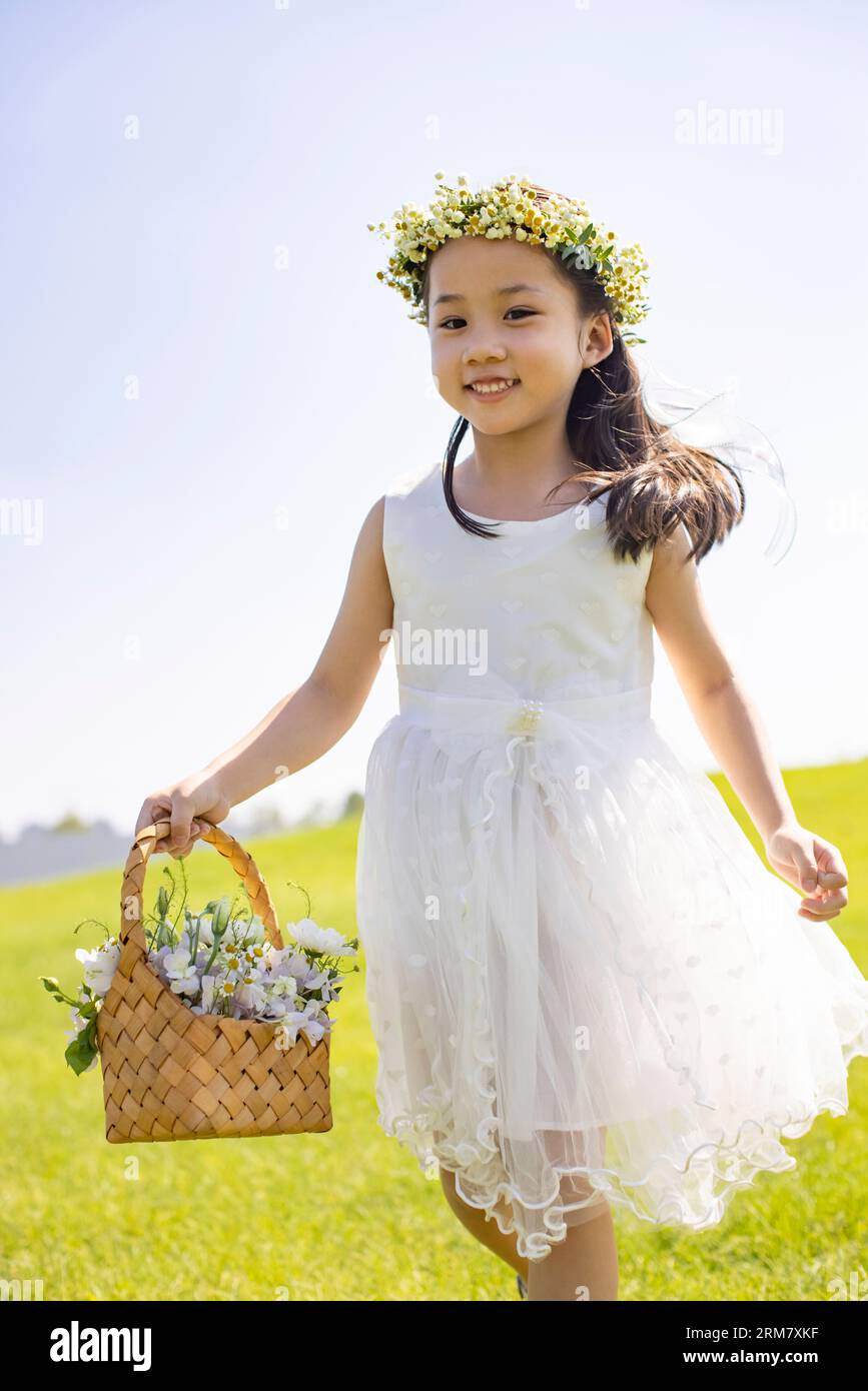 Jolie fille de fleur jouant sur l'herbe Banque D'Images