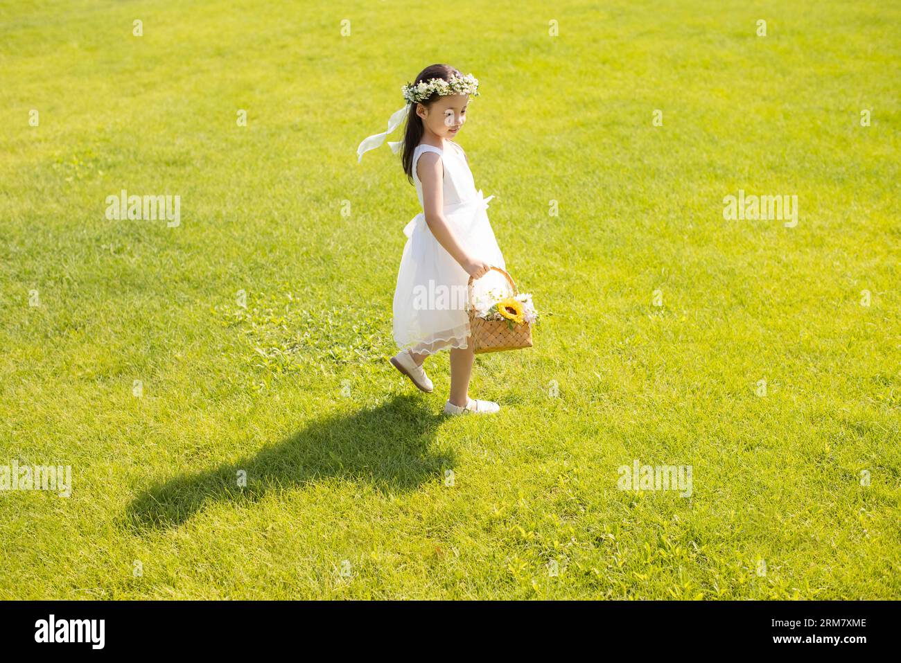 Jolie fille de fleur jouant sur l'herbe Banque D'Images