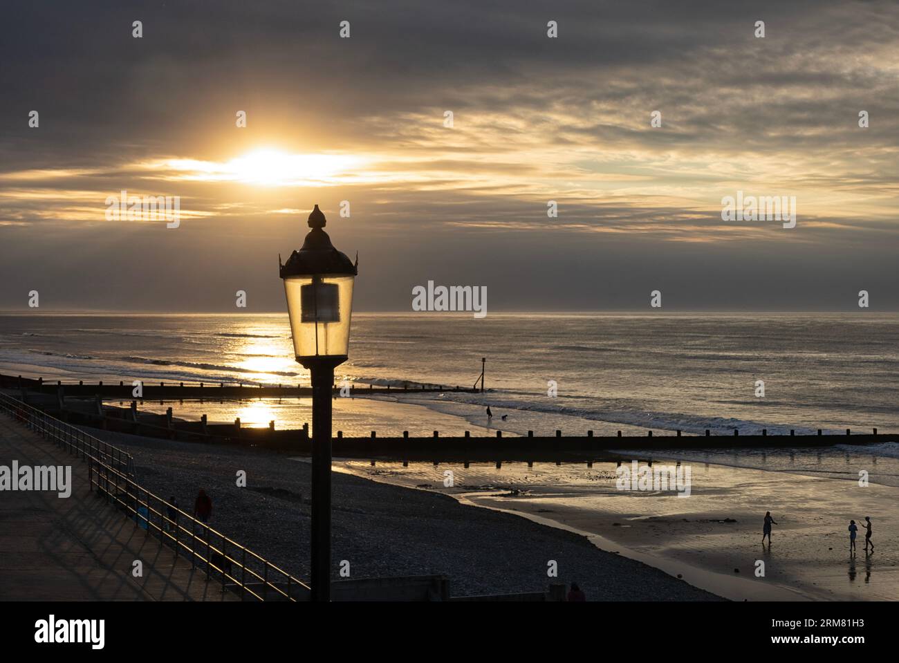 La lumière de lampe victorienne reflétait le soleil au coucher du soleil sur Sheringham Breach, Norfolk, East Anglia, Royaume-Uni Banque D'Images