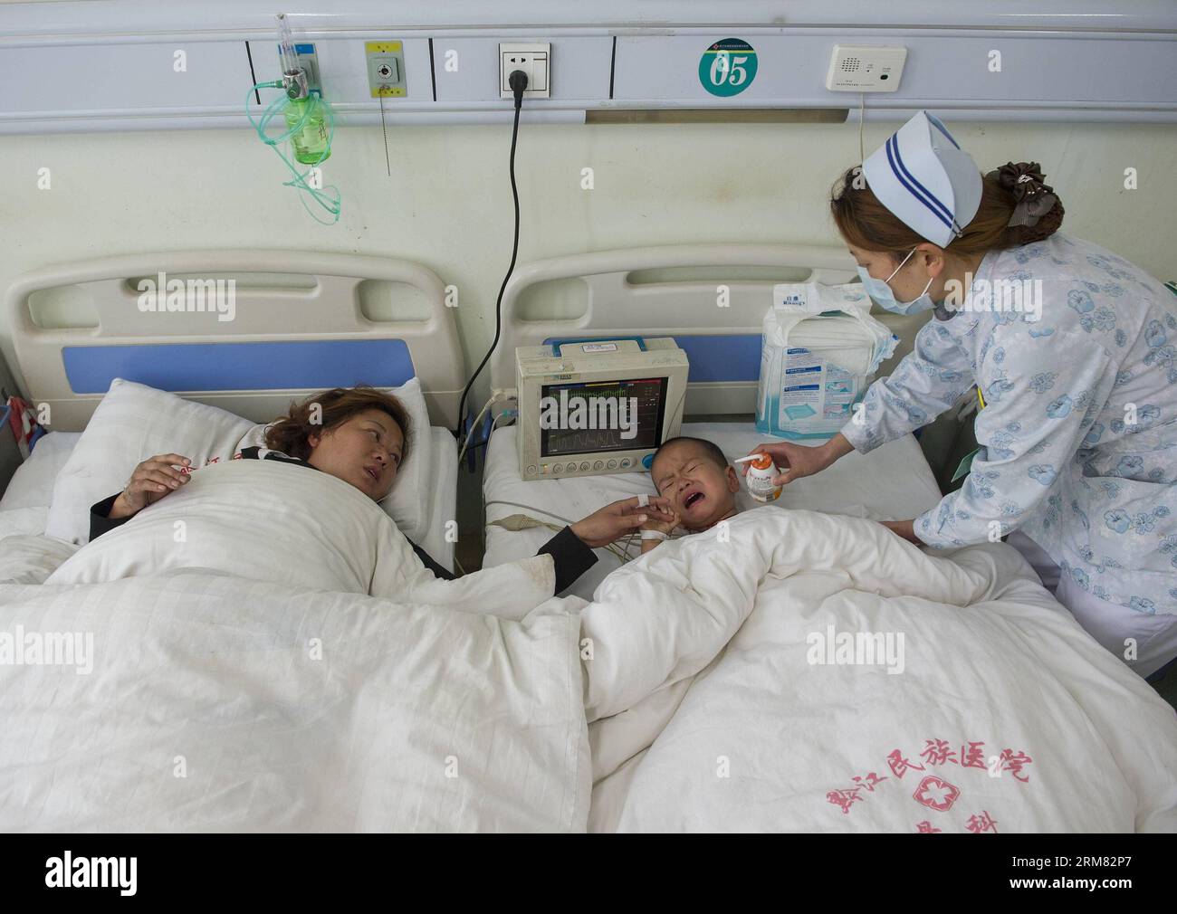 (140325) -- CHONGQING, 25 mars 2014 (Xinhua) -- Wu Jinhong (C), 2 ans, et sa grand-mère Li Congying (L) reçoivent un traitement médical dans un hôpital du district de Qianjiang à Chongqing, dans le sud-ouest de la Chine, le 25 mars 2014. Au moins 15 personnes ont été tuées et 56 autres blessées dans de multiples pilotis mardi sur une section de voie rapide à Chongqing. La cause du toxicomane est toujours à l'étude. (Xinhua/Chen Cheng) (zgp) CHINA-CHONGQING-TRAFFIC ACCIDENT-TREATMENT (CN) PUBLICATIONxNOTxINxCHN Chongqing Mars 25 2014 XINHUA Wu Jinhong C 2 ans et sa grand-mère a quitté l recevoir médical Banque D'Images