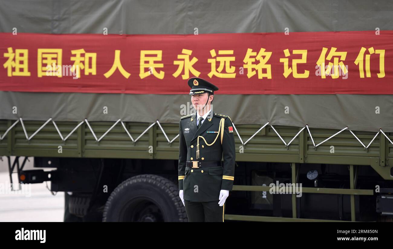 (140328) -- SHENYANG, 28 mars 2014 (Xinhua) -- un soldat de l'Armée populaire de libération chinoise se tient droit devant une bannière Homeland et le peuple se souviendra de vous pour toujours pendant la cérémonie pour recevoir des cercueils contenant les restes de soldats des volontaires du peuple chinois (CPV) morts dans la guerre de Corée de 1950-53, à l'aéroport international de Taoxian à Shenyang, capitale de la province du Liaoning du nord-est de la Chine, le 28 mars 2014. La Corée du Sud a remis vendredi à la Chine les restes de 437 soldats du CPV morts dans la guerre de Corée. (Xinhua/Li Gang) (lfj) LA CHINE-SHENYANG-SOLDATS du CPV-RESTES Banque D'Images