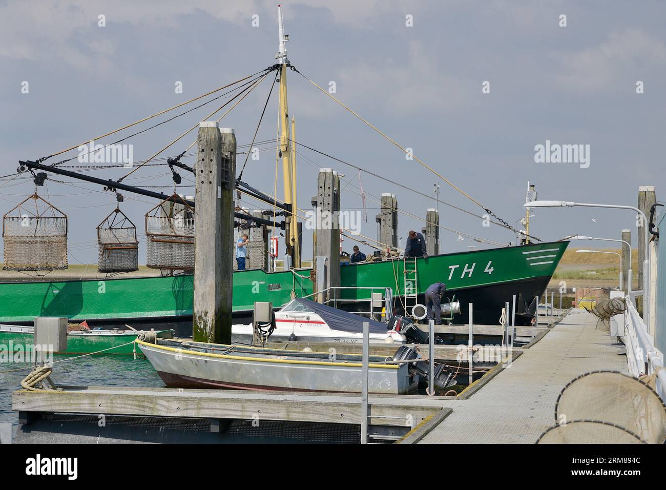 Bateau de pêche vert avec des filets de chalutage surélevés maintenu dans le port d'attache, Bergsediepsluis, Tholen Banque D'Images