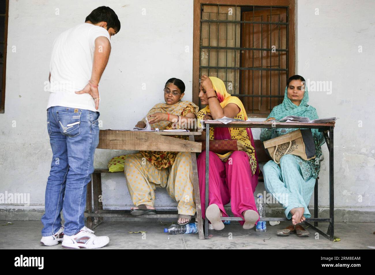 (140410) -- HARYANA, 10 avril 2014 (Xinhua) -- des membres du personnel aident un électeur avant qu'il vote dans un bureau de vote du village de Jhadsa, dans l'État de Haryana, en Inde, le 10 avril 2014. Le vote est en cours jeudi dans une atmosphère généralement pacifique dans 91 circonscriptions à travers 11 États de l'Inde, y compris la capitale New Delhi, dans la troisième phase des élections législatives considérées comme critiques à la fois pour le parti au pouvoir du Congrès et pour le parti d'opposition Bharatiya Janata Party (BJP). (Xinhua/Zheng Huansong) INDE-HARYANA-ELECTIONS GÉNÉRALES-VOTE PUBLICATIONxNOTxINxCHN 140 410 Haryana avril 10 2014 personnel de XINHUA Banque D'Images