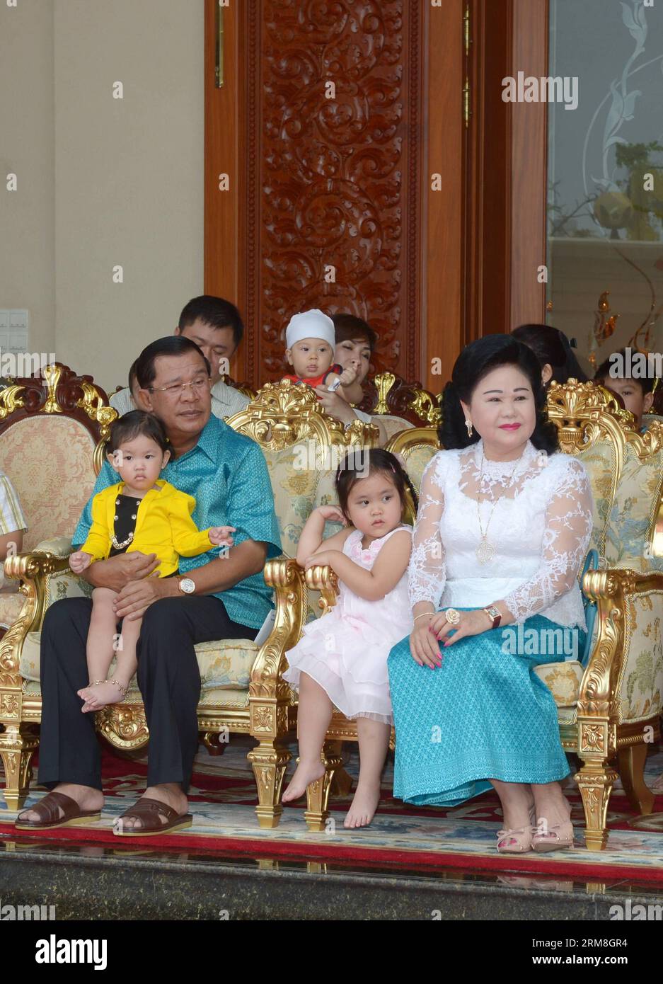 Le Premier ministre cambodgien Hun Sen (à gauche) et son épouse Bun Rany (à droite) siègent avec leurs petits-enfants lors de la célébration du nouvel an khmer à leur résidence à Phnom Penh, Cambodge, le 14 avril 2014. Le Cambodge a organisé lundi une cérémonie élaborée devant la pièce maîtresse du temple Angkor Wat, un site du patrimoine mondial, dans la province de Siem Reap pour saluer le festival Sangkranta ou le nouvel an khmer. (Xinhua/Sovannara) CAMBODGE-PHNOM PENH-KHMER CÉRÉMONIE DU NOUVEL AN PUBLICATIONxNOTxINxCHN les premiers ministres cambodgiens HUN Sen l et son épouse Bun Rany r siègent avec leurs petits-enfants pendant la célébration du nouvel an khmer Banque D'Images