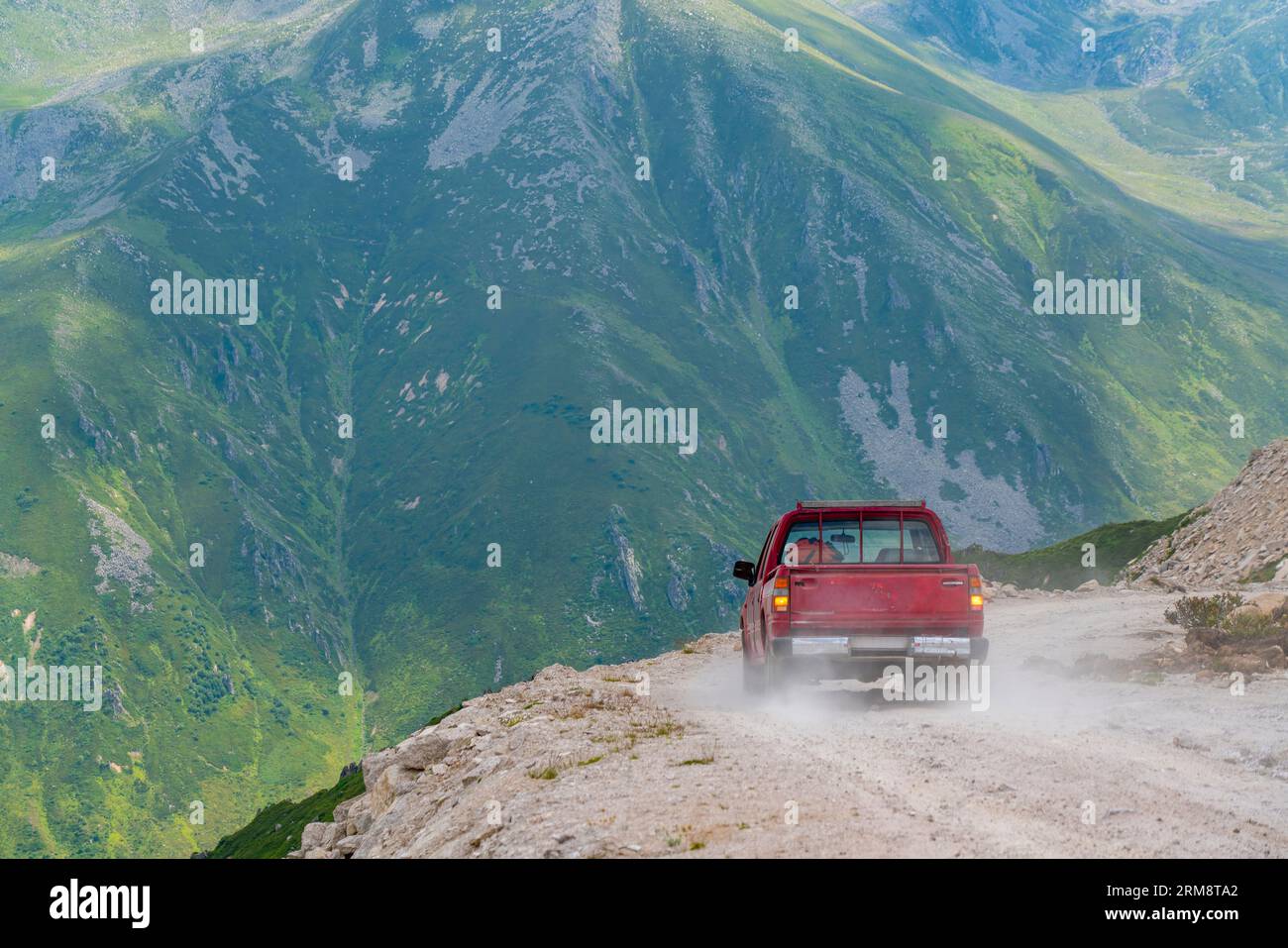 Une camionnette rouge conduisant sur des chemins de terre sur des routes de hauts plateaux en Turquie Banque D'Images