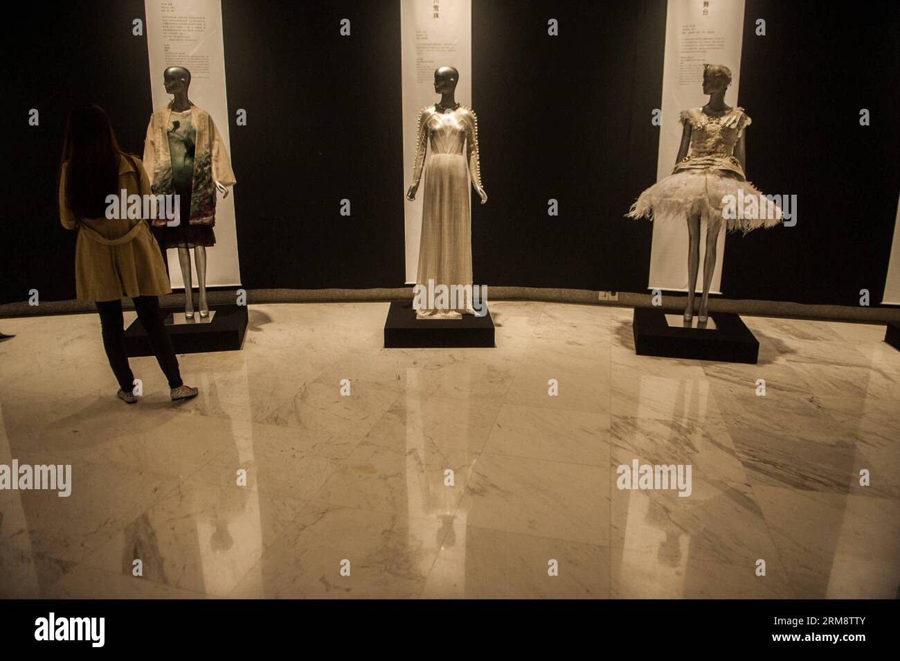 (140427) -- SHENZHEN, 26 avril 2014 (Xinhua) -- Un visiteur voit des expositions pendant la réflexion du temps - l'art de la mode en Chine 1993-2012 à Shenzhen, dans la province du Guangdong du sud de la Chine, le 26 avril 2014. L'exposition, qui présente plus de 100 œuvres créatives de la mode créées par 70 designers chinois au cours des 20 dernières années, est consacrée à présenter le développement global du design de mode chinois et les concepts créatifs. (Xinhua/Mao Siqian)(wyo) CHINA-SHENZHEN-EXHIBITION-ART OF FASHION (CN) PUBLICATIONxNOTxINxCHN Shenzhen avril 26 2014 XINHUA a Visitor Views EXHIBITIONS pendant la réflexion Banque D'Images