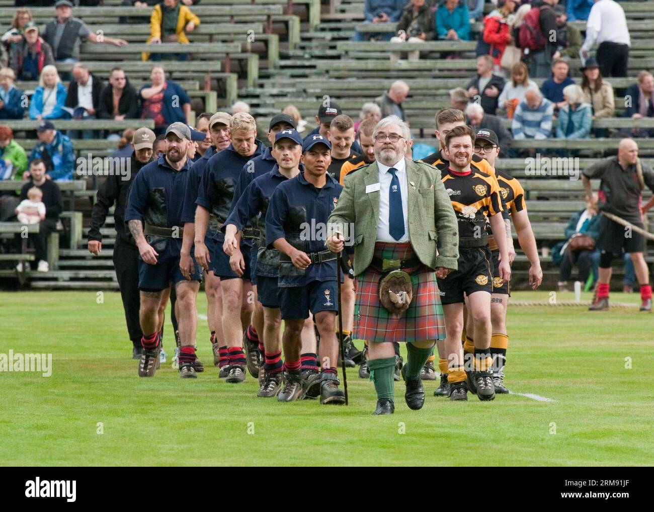 Équipes de remorqueurs de guerre entrant sur le terrain, Braemar Highland Games, Écosse Banque D'Images