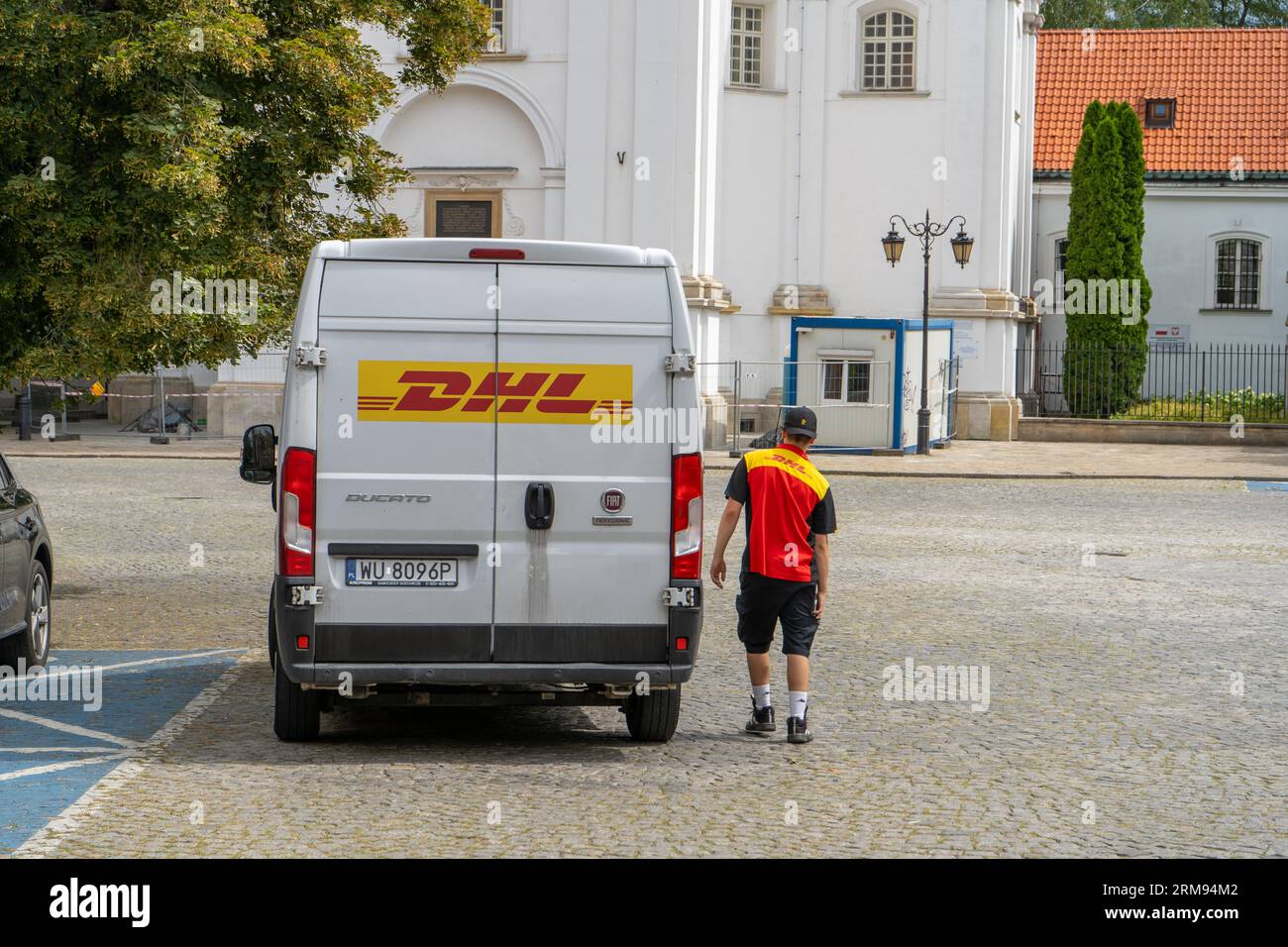 Livraison par DHL. Minibus blanc dans la rue, livraison des colonies et des documents. Pologne, Varsovie - 26 juillet 2023. Banque D'Images