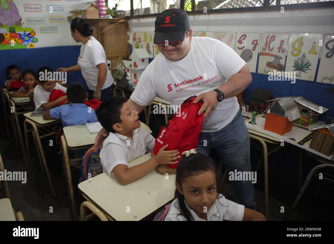 Des bénévoles d’une agence bancaire participent à une livraison de sacs à dos aux enfants d’une institution éducative, dans le cadre d’une initiative visant à contribuer au processus éducatif dans la municipalité d’Izalco, dans le département de Sonsonate, à 65 km à l’ouest de San Salvador, capitale du Salvador, le 7 mai 2014. (Xinhua/Oscar Rivera) (rt) EL SALVADOR-IZALCO-SOCIETY-VOLUNTEERS PUBLICATIONxNOTxINxCHN les volontaires d'une agence bancaire participent à une livraison de sac à dos aux enfants de l'institution éducative dans le cadre de l'Initiative pour contribuer au processus d'éducation dans la municipalité dans le Depar Banque D'Images