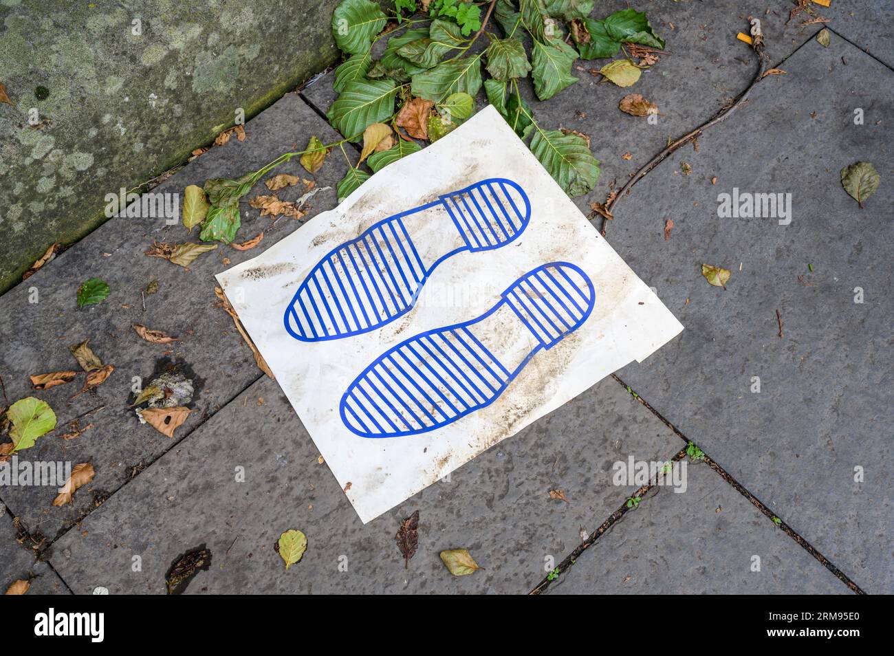 Emballage bleu jeté sur un trottoir Banque D'Images