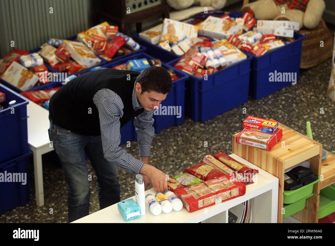 Un bénévole emballe de la nourriture pour les personnes dans le besoin au Centre d’accueil et de solidarité de la municipalité d’Athènes (KYADA) dans le centre-ville d’Athènes, Grèce, le 9 mai 2014. La crise de la dette en cours en Grèce a porté à 20 000 le nombre de personnes sollicitant l’aide de la KYADA, contre 3 000 avant la crise. (Xinhua photo/Marios Lolos) GRÈCE-ATHÈNES-CHARITÉ-BÉNÉVOLES-DISTRIBUTION ALIMENTAIRE PUBLICATIONxNOTxINxCHN un volontaire emballe de la nourriture pour les célébrités dans le besoin au Centre d'accueil et de solidarité de la municipalité d'Athènes dans le centre d'Athènes en Grèce LE 9 2014 mai la crise de la dette en cours dans GRE Banque D'Images