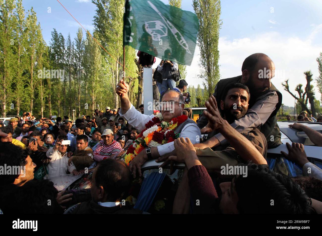 (140516) -- SRINAGAR, 16 mai 2014 (Xinhua) -- Tariq Hamid Kara, chef du principal parti d opposition du Cachemire contrôlé par l Inde, le Parti démocratique du peuple (PDP), tient un drapeau du parti alors que les gens le saluent après qu il a été déclaré vainqueur pour un siège parlementaire, à Srinagar, la capitale estivale du Cachemire contrôlé par l Inde, le 16 mai 2014. (Xinhua/Javed Dar) INDE-CACHEMIRE-SRINAGAR-ELECTIONS GÉNÉRALES PUBLICATIONxNOTxINxCHN Srinagar Mai 16 2014 XINHUA Tariq Hamid Karabakh Chef du Cachemire contrôlé par l'Inde S principal parti d'opposition Parti démocratique populaire PDP tient un drapeau du parti alors que des célébrités le saluent Afte Banque D'Images