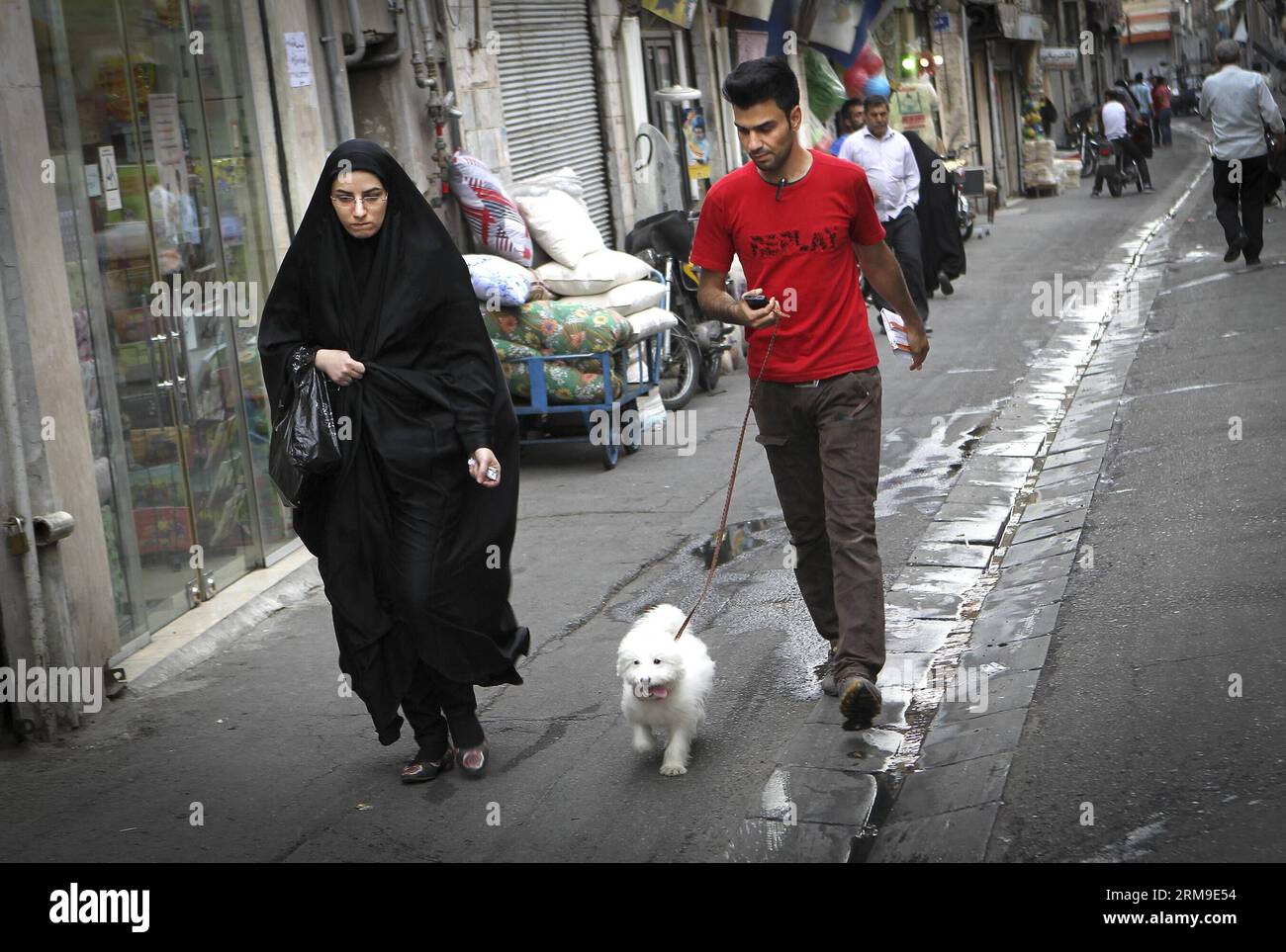 (140520) -- TÉHÉRAN, 20 mai 2014 (Xinhua) -- Une femme vêtue de tchador marche dans une rue de Téhéran, capitale de l'Iran, le 19 mai 2014. Chador est une sorte de hijab formel pour de nombreuses femmes en Iran dans les lieux publics. Le hijab, une couverture des cheveux et du corps pour les femmes, a été rendu public après la révolution islamique en Iran en 1979. (Xinhua/Ahmad Halabisaz)(zhf) IRAN-TEHRAN-WOMEN-HIJAB PUBLICATIONxNOTxINxCHN TEHRAN Mai 20 2014 XINHUA une femme vêtue de tchador marche DANS une rue à TÉHÉRAN capitale de l'Iran Mai 19 2014 chador EST un enfant du hijab formel pour BEAUCOUP DE femmes en Iran dans les lieux publics hijab une couverture de Banque D'Images