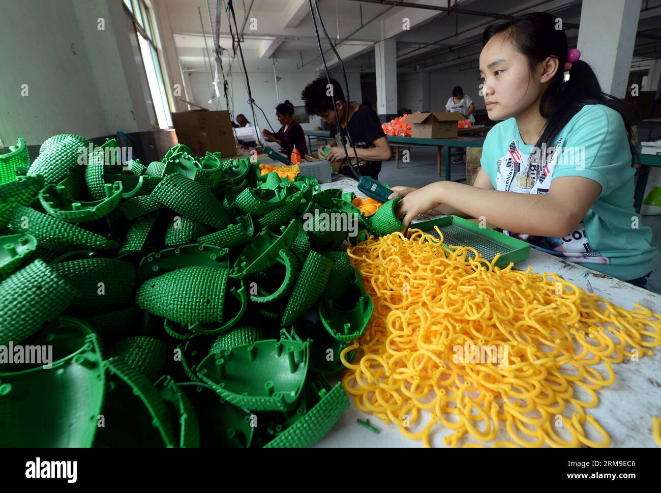 (140520) -- YIWU, mai 20, 2014 (Xinhua) -- les travailleurs fabriquent des Caxirolas dans une usine à Yiwu, province de Zhejiang de l'est de la Chine, mai 20, 2014. Les commandes à l'étranger ont explosé depuis que les usines de Yiwu, une petite ville de marchandises, ont commencé à produire Caxirola, l'instrument de percussion officiel de la prochaine coupe du monde de la FIFA 2014, en octobre 2013. Environ 90 pour cent des Caxirolas du monde sont fabriqués dans des usines basées à Zhejiang et Guangdong, deux centres de fabrication de la Chine. Les usines chinoises ont également fait fortune en vendant des cornes de Vuvuzela lors de la coupe du monde de football 2010 en Afrique du Sud. (Xinhua/Wang Dingc Banque D'Images