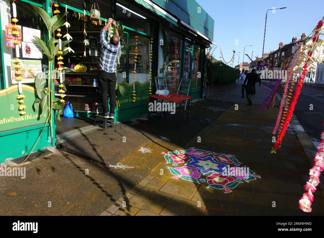 Londres, Royaume-Uni. 27 août 2023. Des membres de la communauté tamoule hindoue se réunissent à East Ham pour célébrer Rathayatra, qui voit des chars défiler dans les rues, accompagnés de cérémonies religieuses. Les rues à l'extérieur des magasins le long de la rue principale sont décorées avec des motifs de mandala colorés, et la plupart des gens portent des vêtements indiens traditionnels. © Simon King/ Alamy Live News Banque D'Images