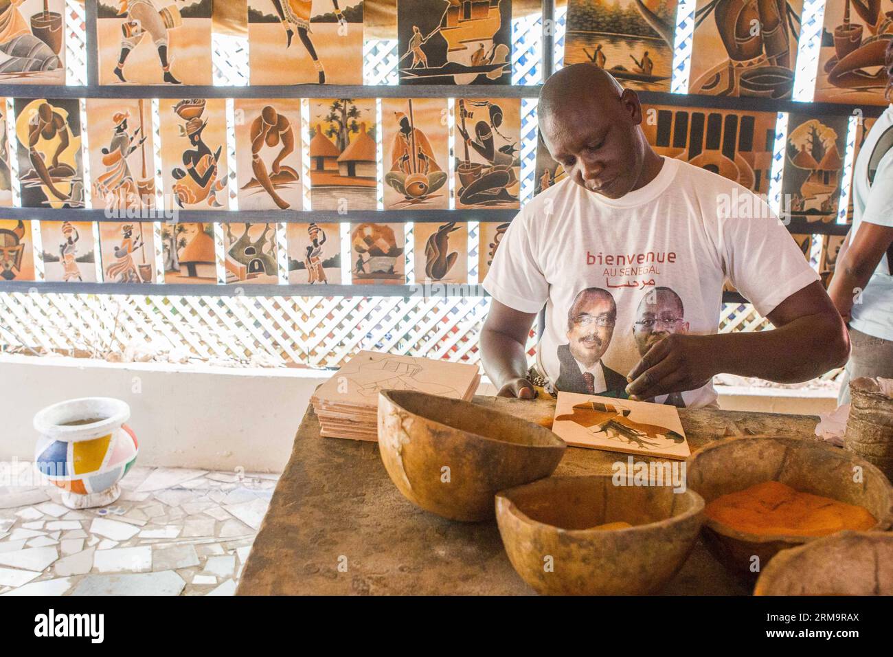 (140530) -- DAKAR, 30 mai 2014 (Xinhua) -- un artiste réalise des peintures sur sable à la galerie Dougoub de l'île de Gorée à Dakar, capitale du Sénégal, le 24 mai 2014. La 11e édition de la Biennale d’art contemporain africain, Dak Art, se tient au Sénégal du 9 mai au 8 juin. Dakar est situé sur la péninsule du Cap-Vert sur la côte atlantique. Sa position, à la limite occidentale de l’Afrique, est un avantage pour l’intégration de l’art contemporain africain dans le marché international de l’art. (Xinhua/Li Jing) SENEGAL-DAKAR-CULTURE-ART PUBLICATIONxNOTxINxCHN Dakar Mai 30 2014 XINHUA to Artist Makes Sand Pai Banque D'Images