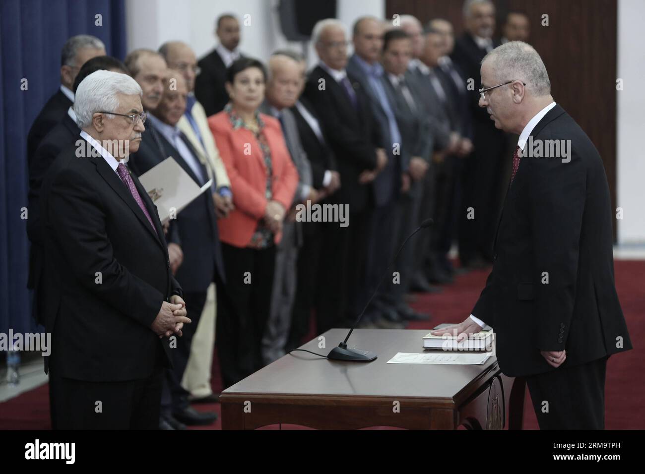 (140602) -- RAMALLAH, 2 juin 2014 (Xinhua) - le Premier ministre palestinien Rami Al-Hamdallah (R) prête serment devant le président Mahmoud Abbas (front de gauche) lors de la cérémonie d'assermentation du nouveau gouvernement d'unité dans la ville de Ramallah, rive ouest, le 2 juin 2014. Le président palestinien Mahmoud Abbas a annoncé lundi la fin d’une division politique de sept ans entre son parti Fatah et le mouvement islamique Hamas. (Xinhua/Fadi Arouri) (zjy) MIDEAST-RAMALLAH-UNITY-GOVERNMENT PUBLICATIONxNOTxINxCHN Ramallah juin 2 2014 XINHUA Premier ministre PALESTINIEN Rami Al Hamdallah r PRÊTE SERMENT devant P Banque D'Images